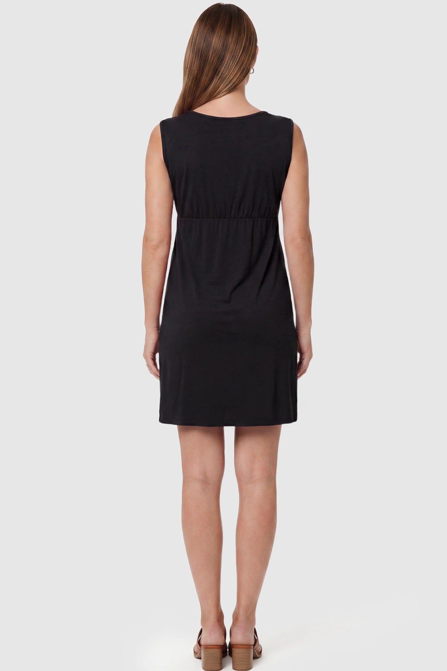 Sleeveless Empire Waist Maternity Short Dress Sleeveless empire waist maternity short dress in black with short length and sleeveless design, back view on pregnant model