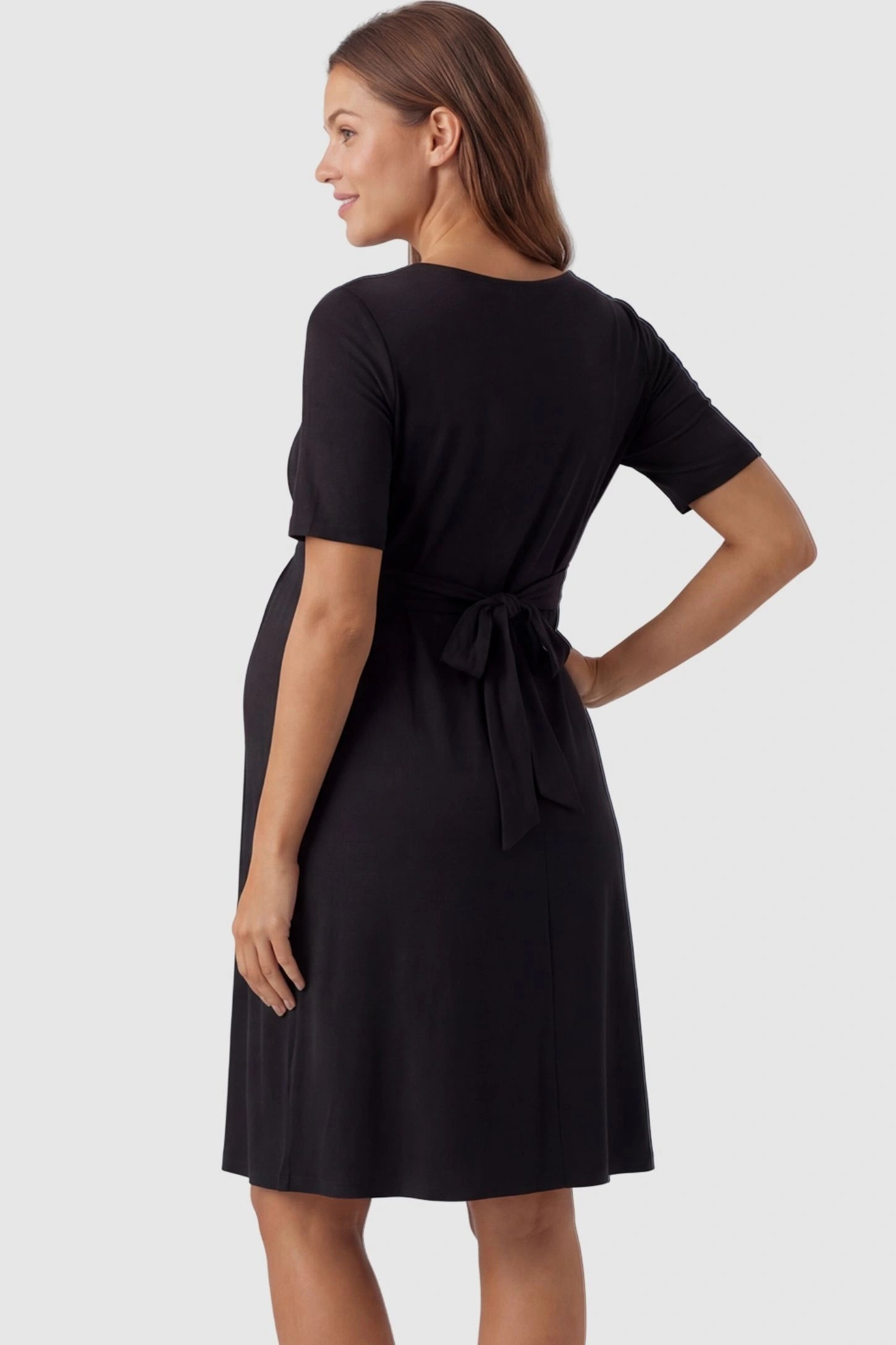 V-Neck Empire Waist Short Maternity & Nursing Dress V-Neck Empire Waist Short Maternity and Nursing Dress in black featuring adjustable tie in full body back view on a pregnant model