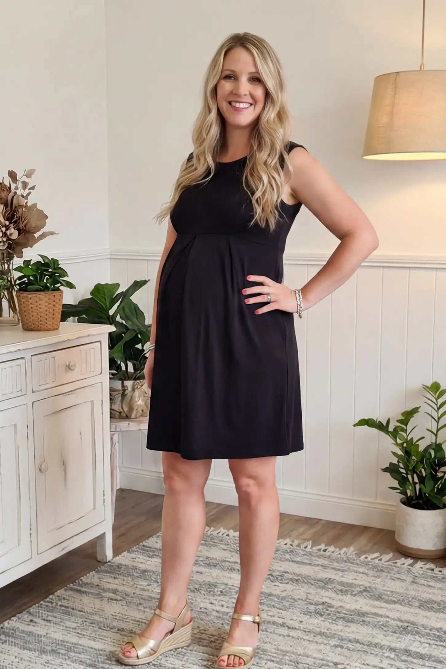 Sleeveless Empire Waist Maternity Short Dress Sleeveless empire waist maternity short dress in black with short length and sleeveless design, front view on pregnant model