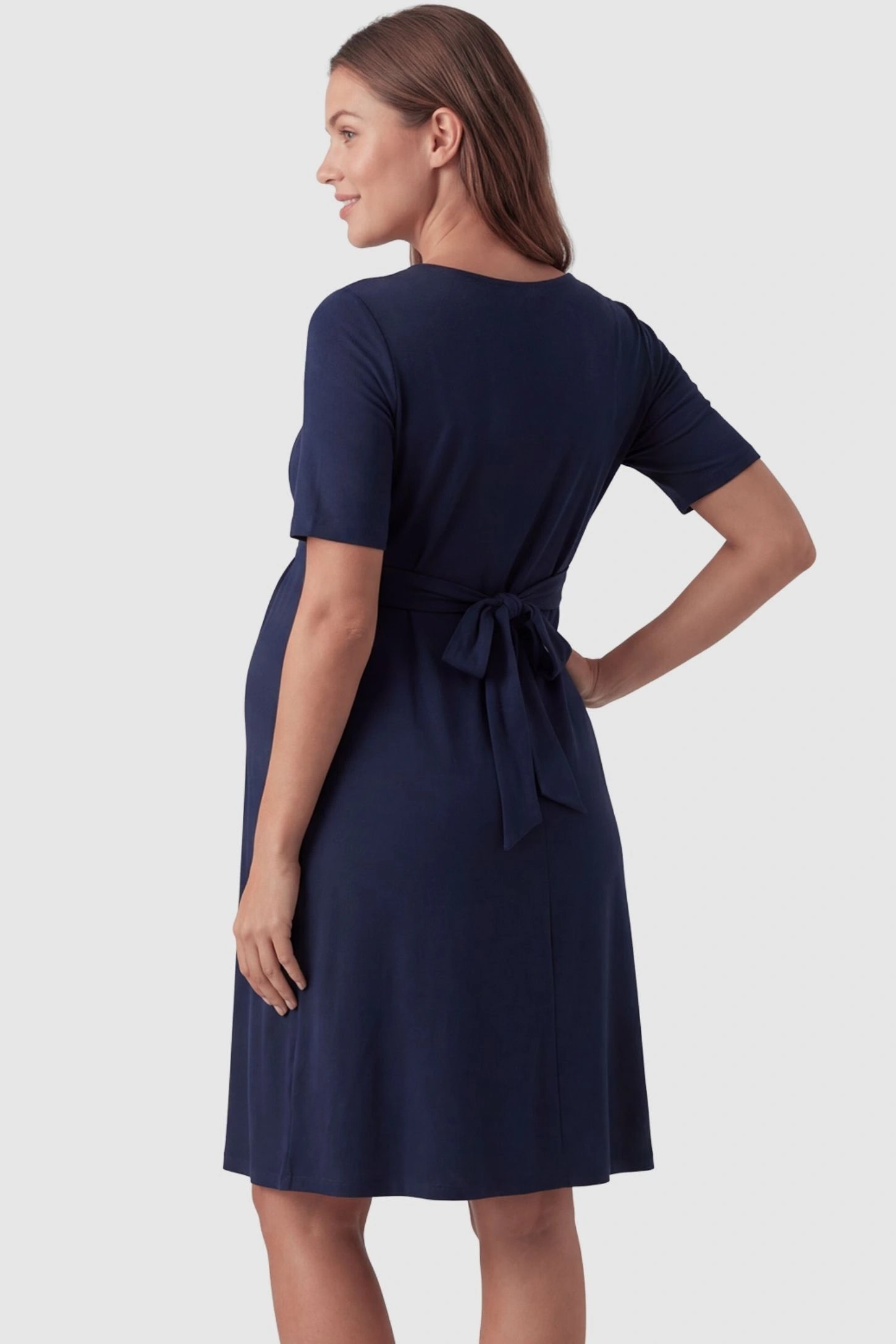 V-Neck Empire Waist Short Maternity & Nursing Dress V-Neck Empire Waist Short Maternity and Nursing Dress in navy blue featuring adjustable tie in full body back view on a pregnant model