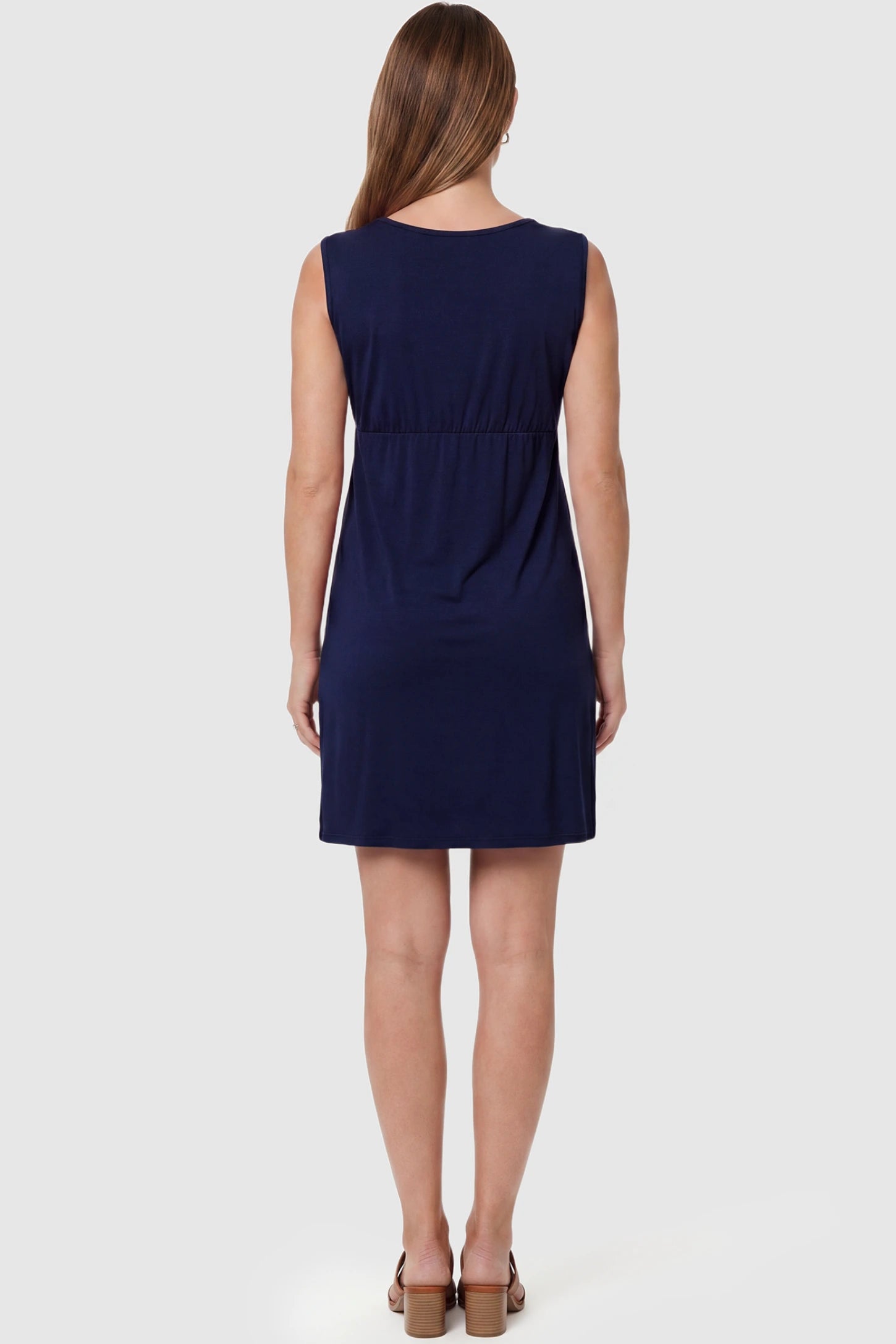 Sleeveless Empire Waist Maternity Short Dress Sleeveless empire waist maternity short dress in navy blue with short length and sleeveless design, back view on pregnant model