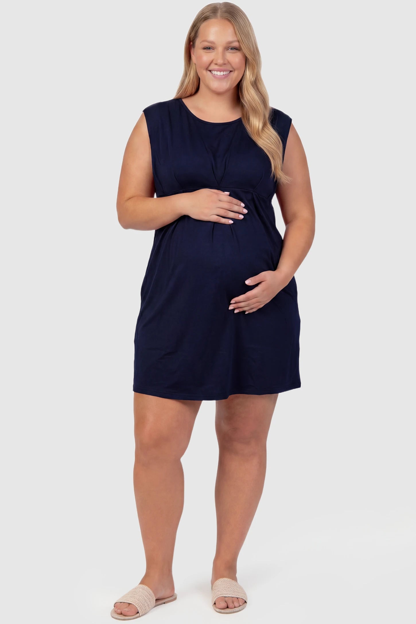 Sleeveless Empire Waist Maternity Short Dress Sleeveless empire waist maternity short dress in navy blue with short length and sleeveless design, front view on plus-size model