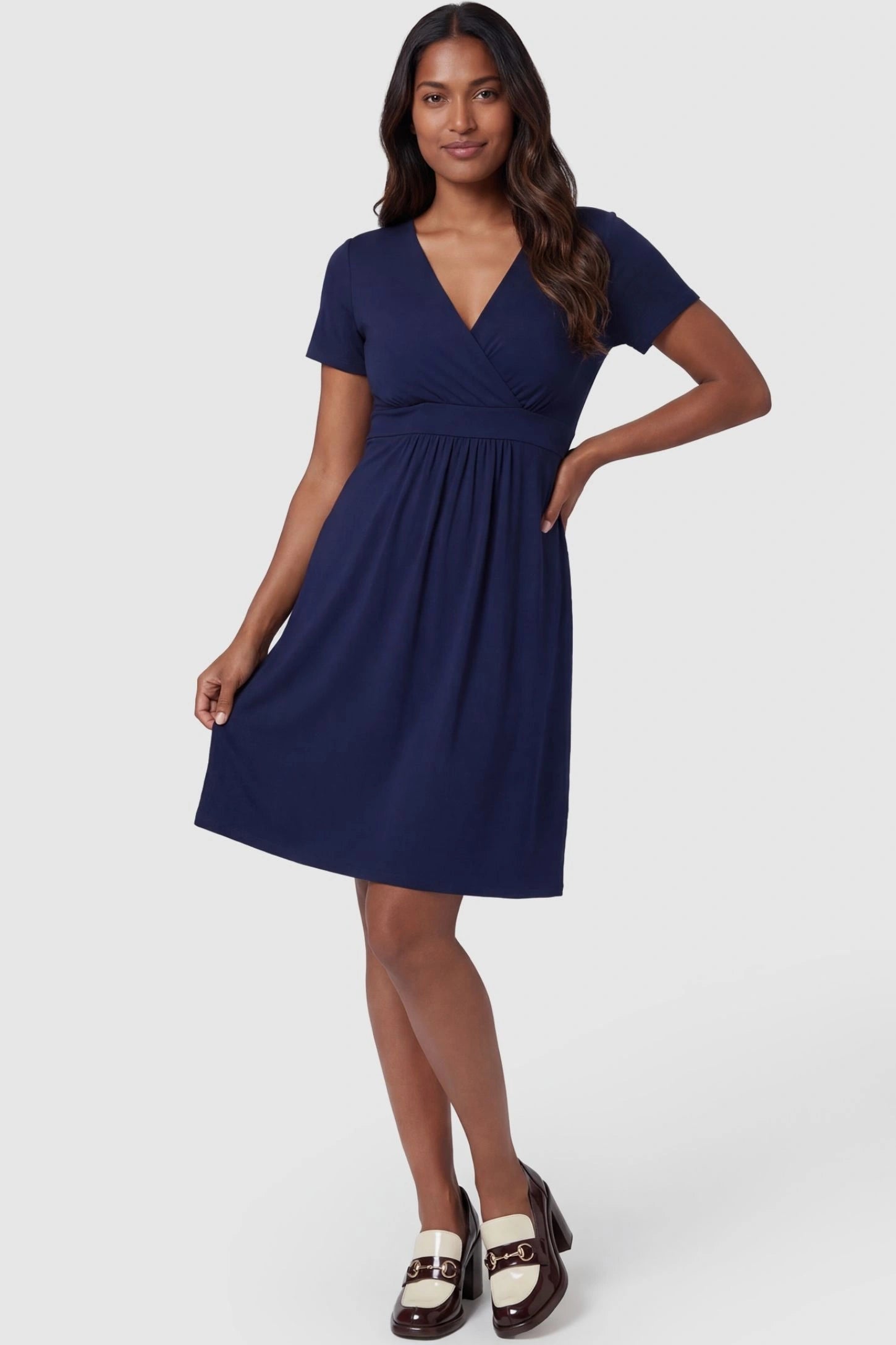 V-Neck Empire Waist Short Maternity & Nursing Dress V-Neck Empire Waist Short Maternity and Nursing Dress in navy blue featuring A-line silhouette in full body front view on a postpartum model