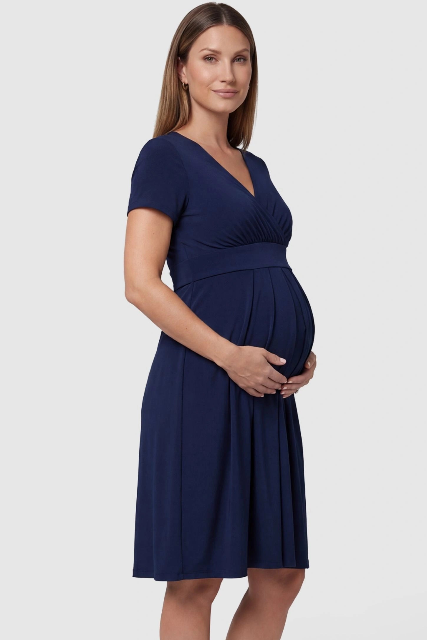 V-Neck Empire Waist Short Maternity and Nursing Dress in navy blue featuring short-sleeve in full body side view on a pregnant model