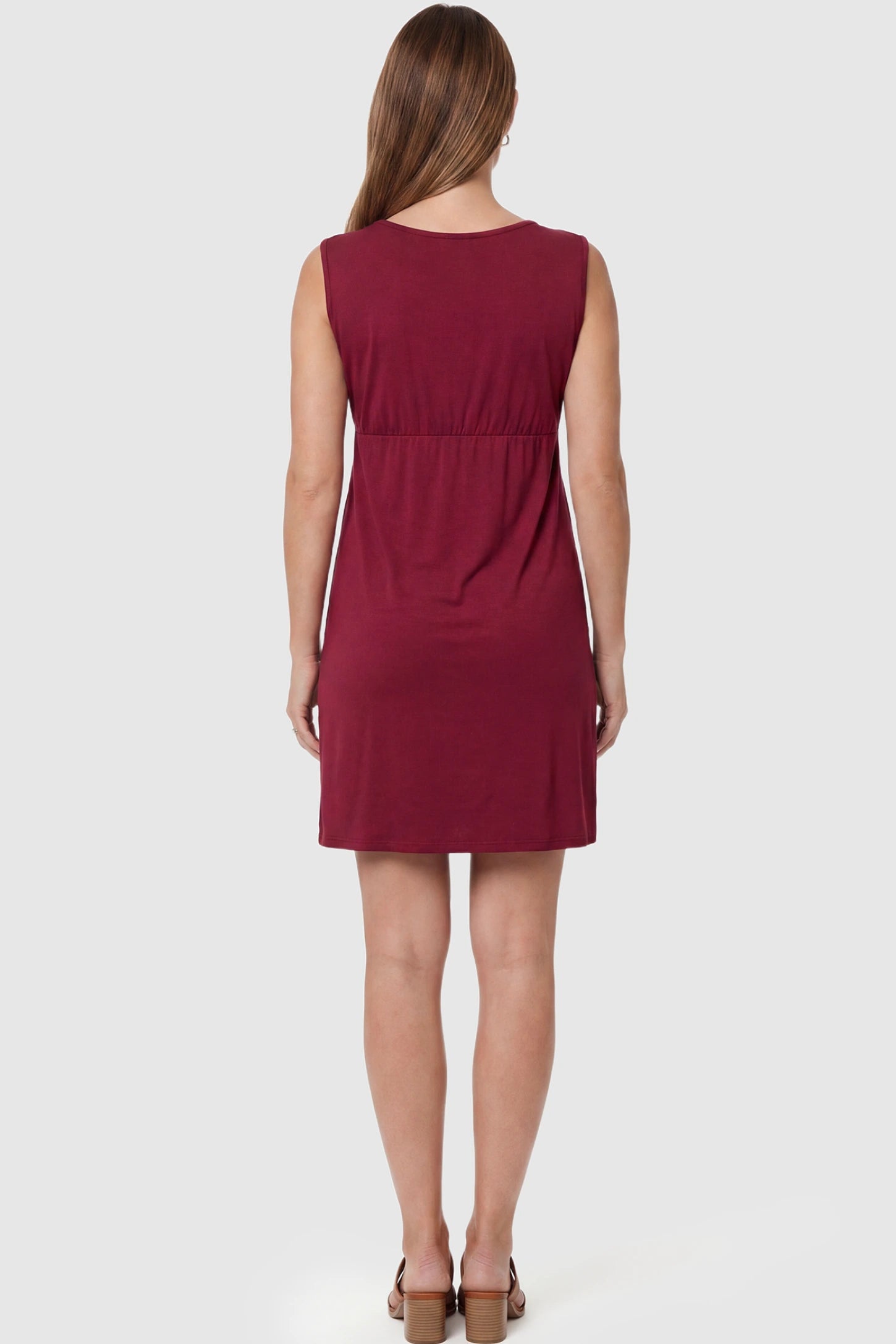 Sleeveless Empire Waist Maternity Short Dress Sleeveless empire waist maternity short dress in wine red with short length and sleeveless design, back view on pregnant model