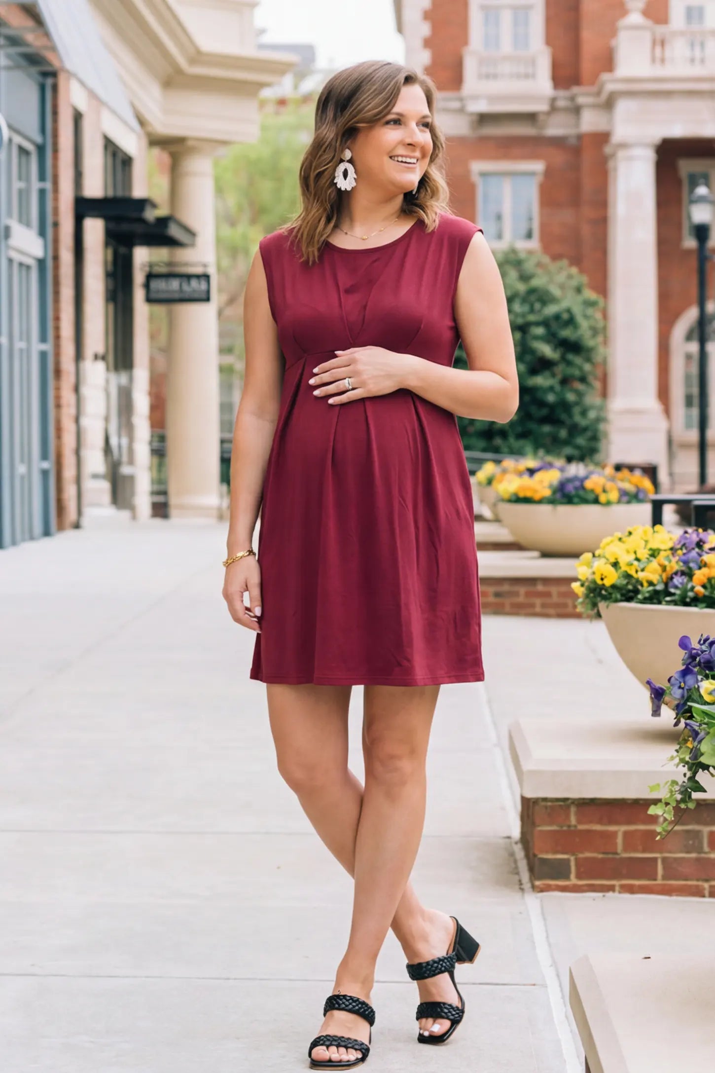 Sleeveless Empire Waist Maternity Short Dress Sleeveless empire waist maternity short dress in wine red with short length and sleeveless design, front view on pregnant model