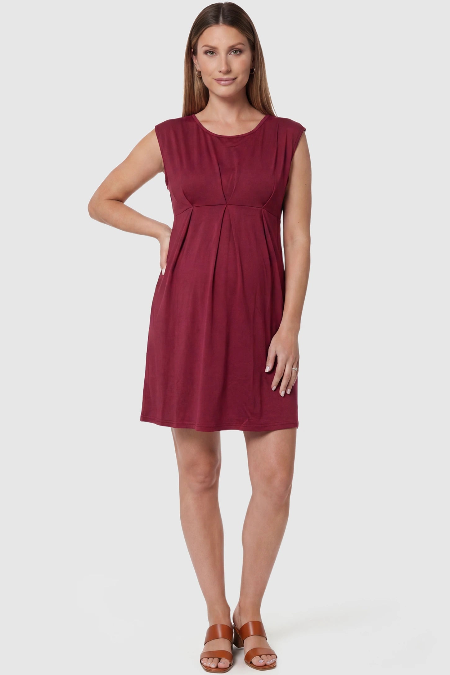 Sleeveless Empire Waist Maternity Short Dress Sleeveless empire waist maternity short dress in wine red with short length and sleeveless design, front view on pregnant model