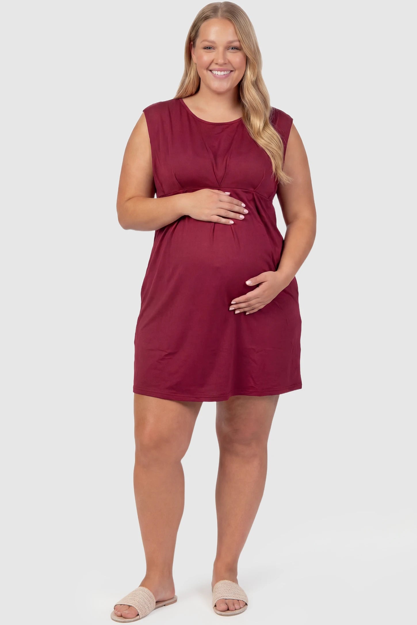Sleeveless Empire Waist Maternity Short Dress Sleeveless empire waist maternity short dress in wine red with short length and sleeveless design, front view on plus-size model