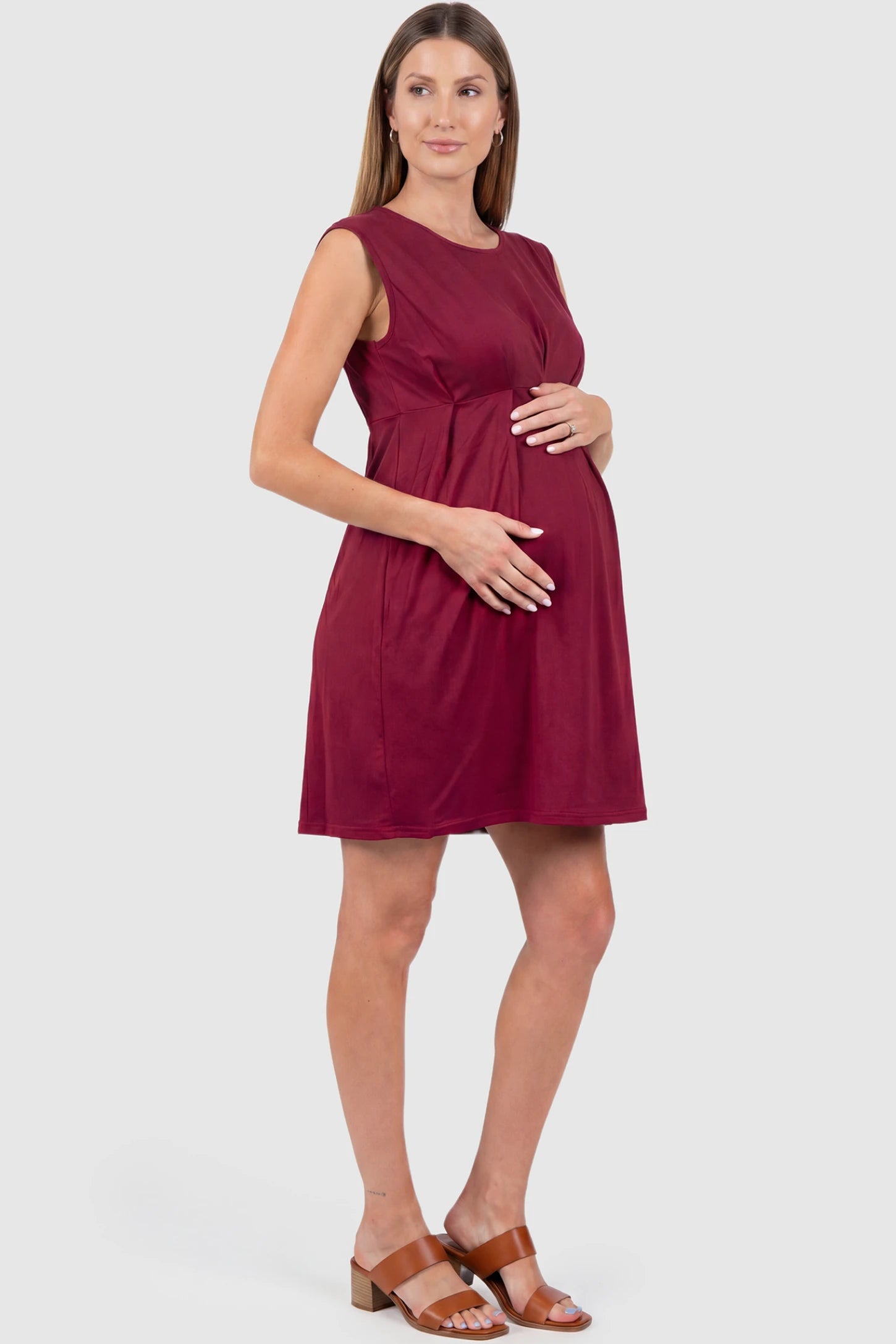 Sleeveless Empire Waist Maternity Short Dress Sleeveless empire waist maternity short dress in wine red with short length and sleeveless design, side view on pregnant model