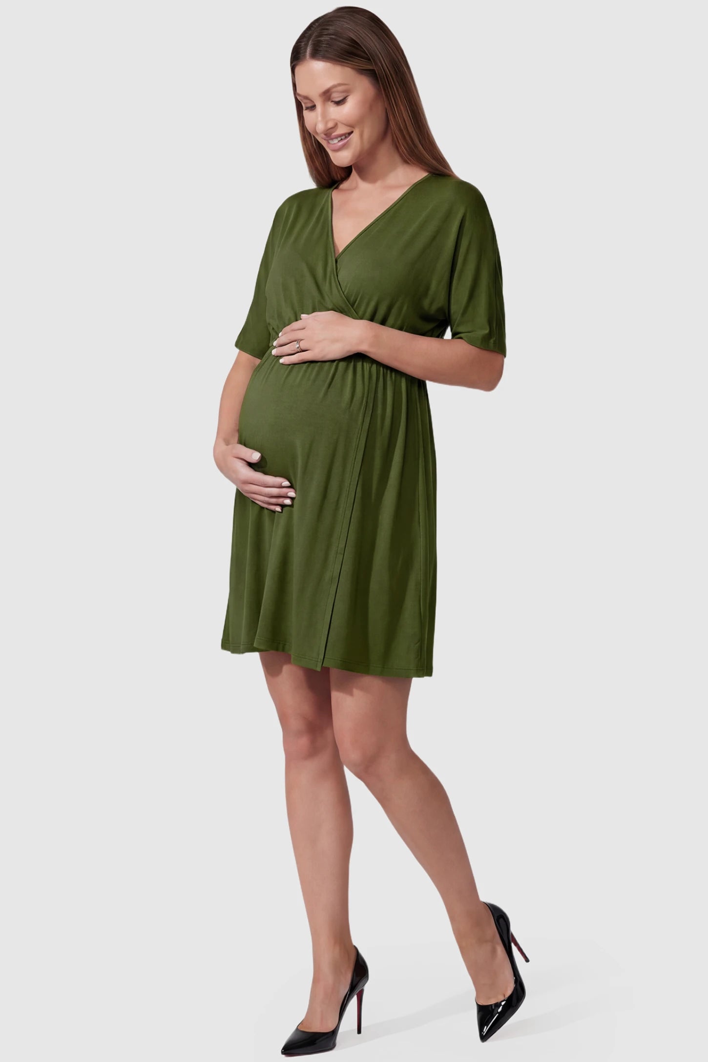 Wrap Front Empire Waist Maternity & Nursing Mini Dress Wrap Front Empire Waist Maternity & Nursing Dress in army green featuring a draped crossover V-neck and short sleeves on pregnant model front view.
