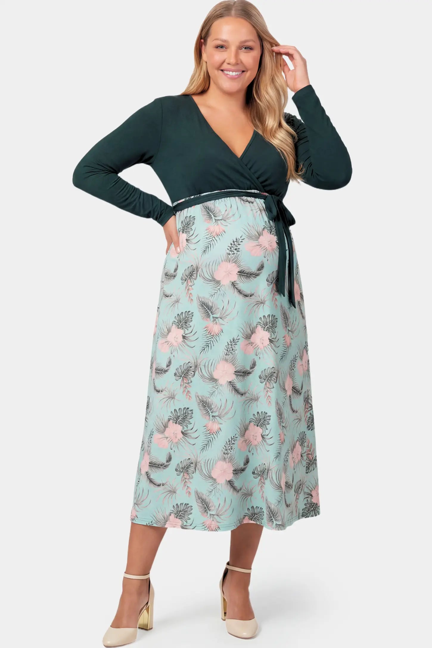 Empire Waist Faux Wrap Maternity & Nursing Midi Dress Empire Waist Faux Wrap Maternity & Nursing Midi Dress in green floral featuring long sleeves and V-neck wrap detail on a plus size pregnant model.