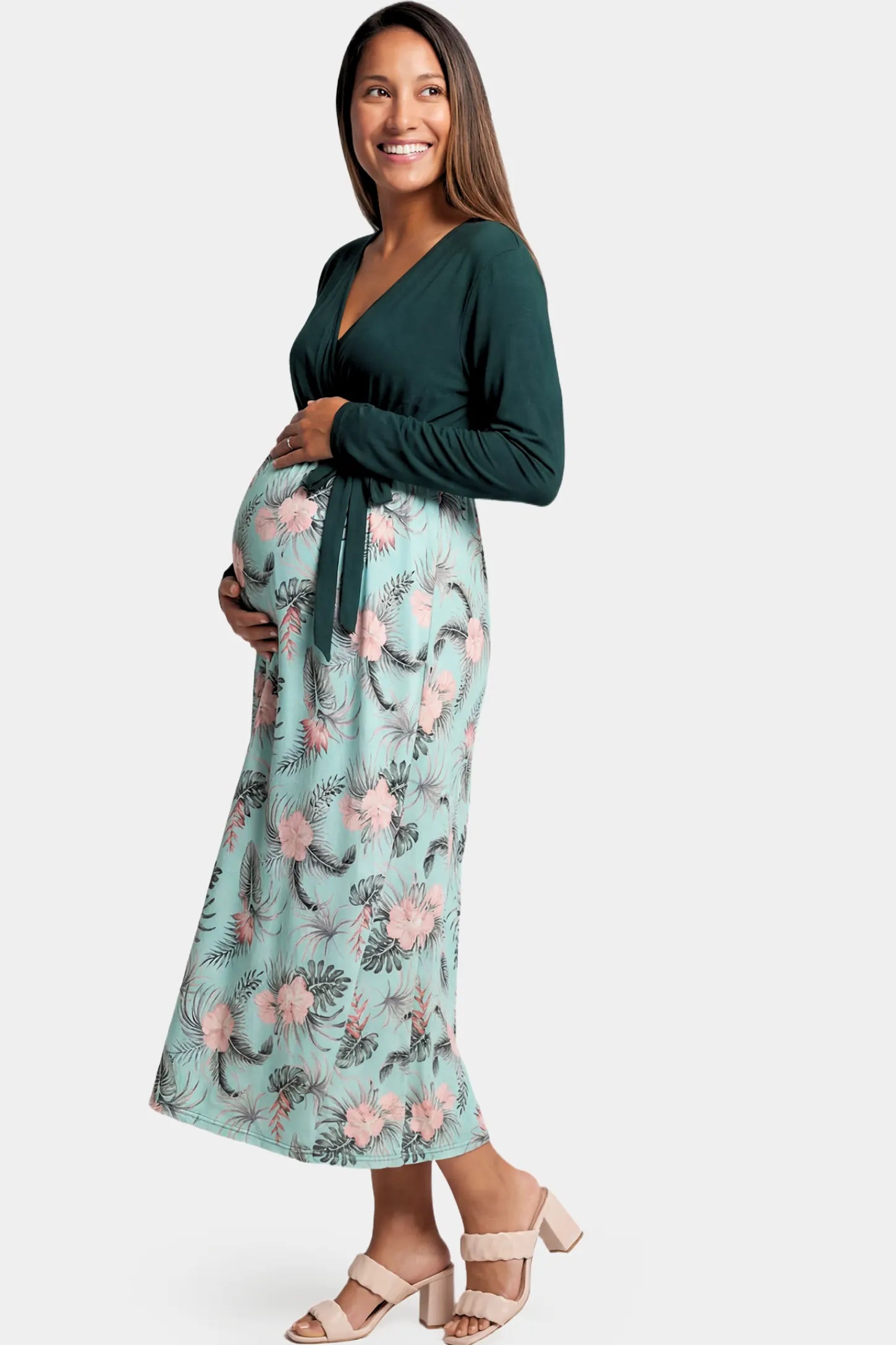 Empire Waist Faux Wrap Maternity & Nursing Midi Dress in green floral featuring long sleeves and V-neck wrap detail on a pregnant model.