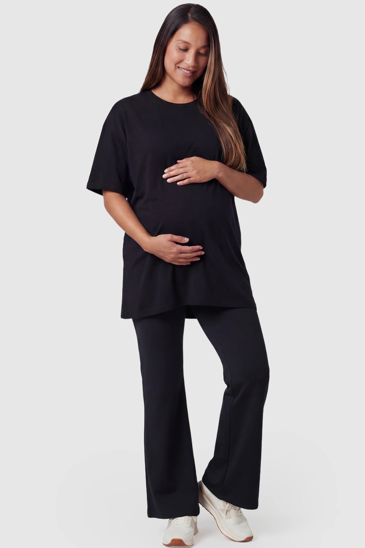 Full-Panel Flared Maternity Pants in black featuring high-waisted bump panel and full-length bootcut silhouette on pregnant model.