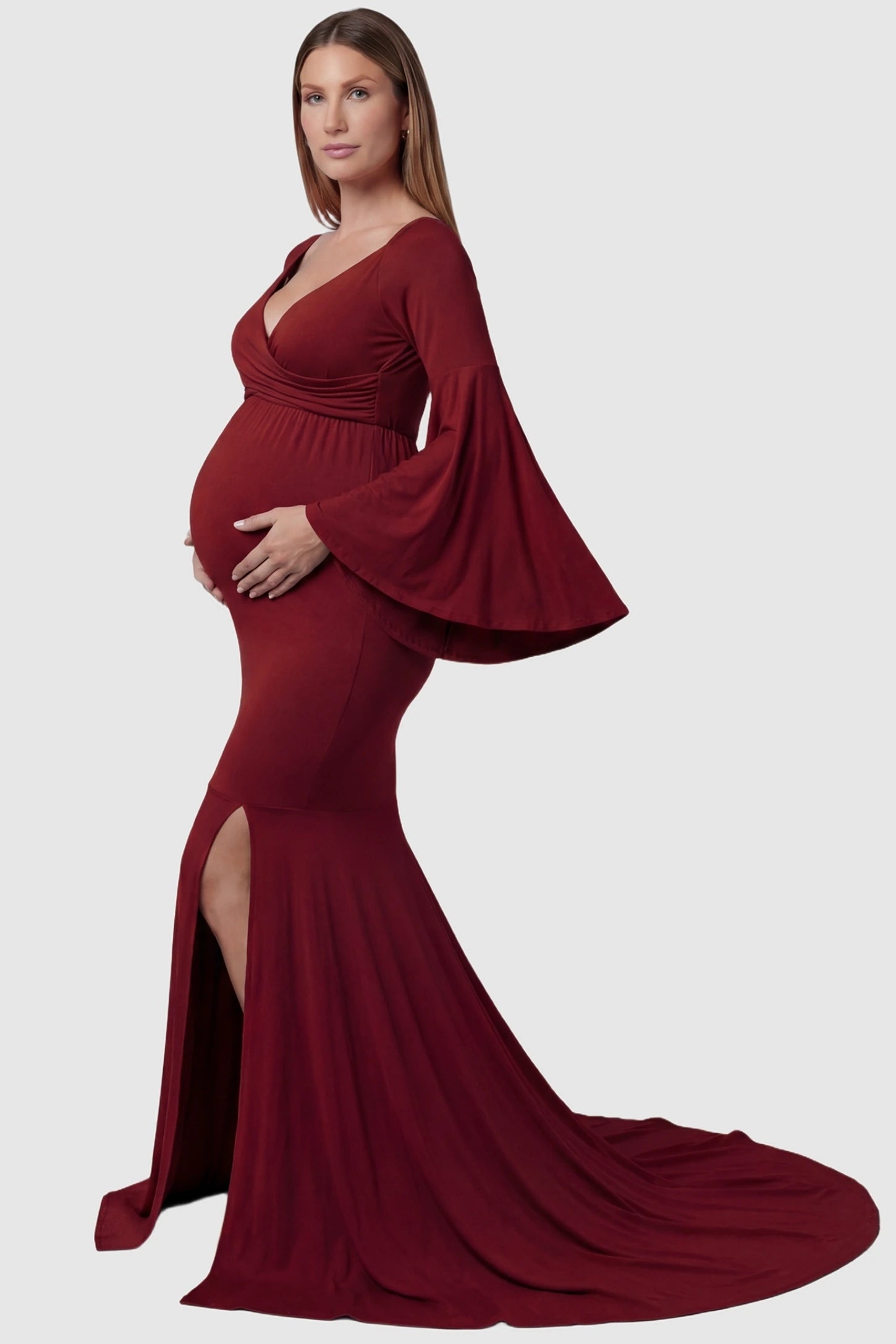 Wrap Flared Fishtail Maternity Gown Wrap Flared Fishtail Maternity Gown in Burgundy featuring a dramatic long train on a pregnant model side view.