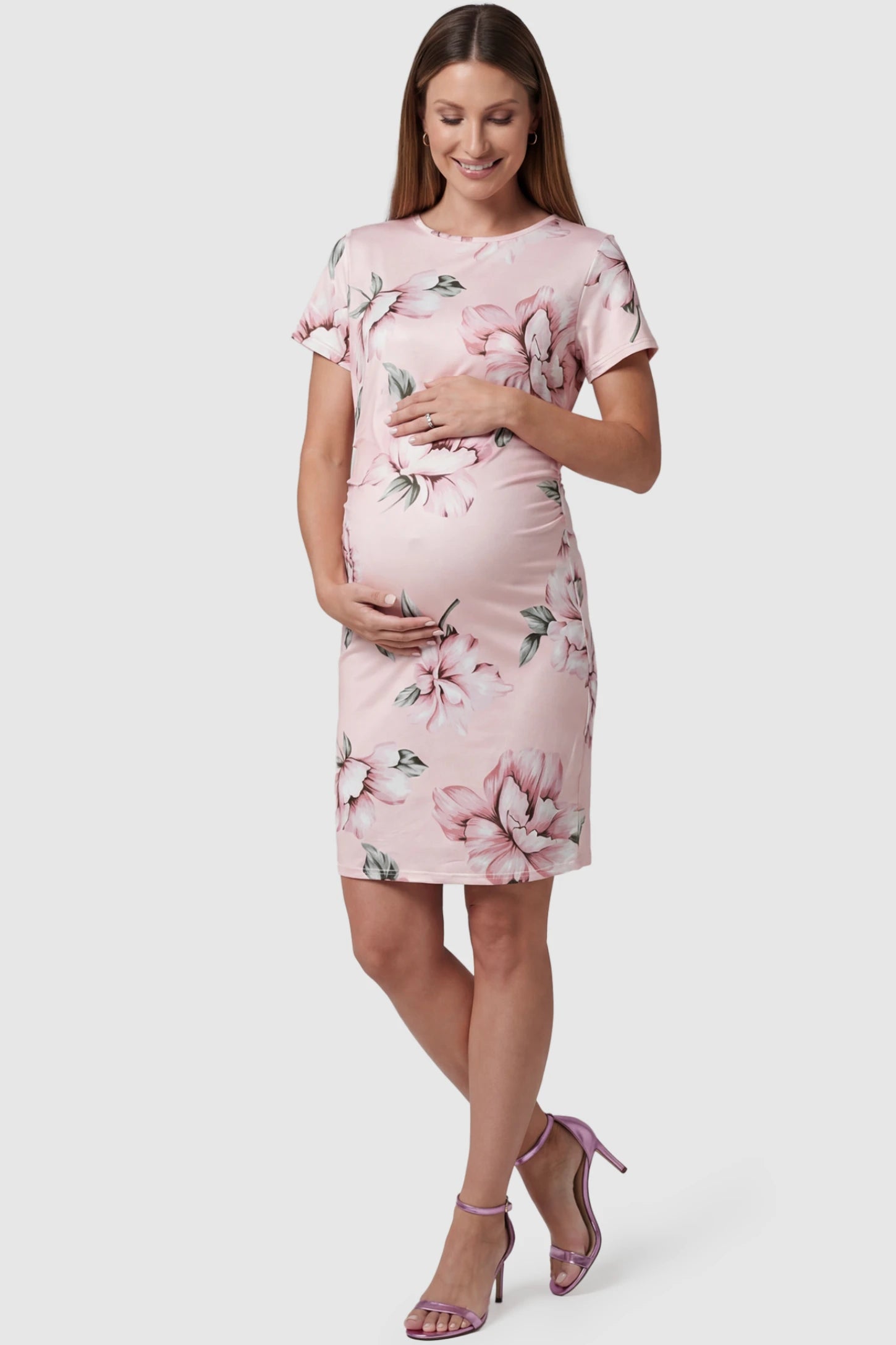 Floral Ruched Bodycon Maternity Short Dress in pink floral featuring side ruching on pregnant model, front view.