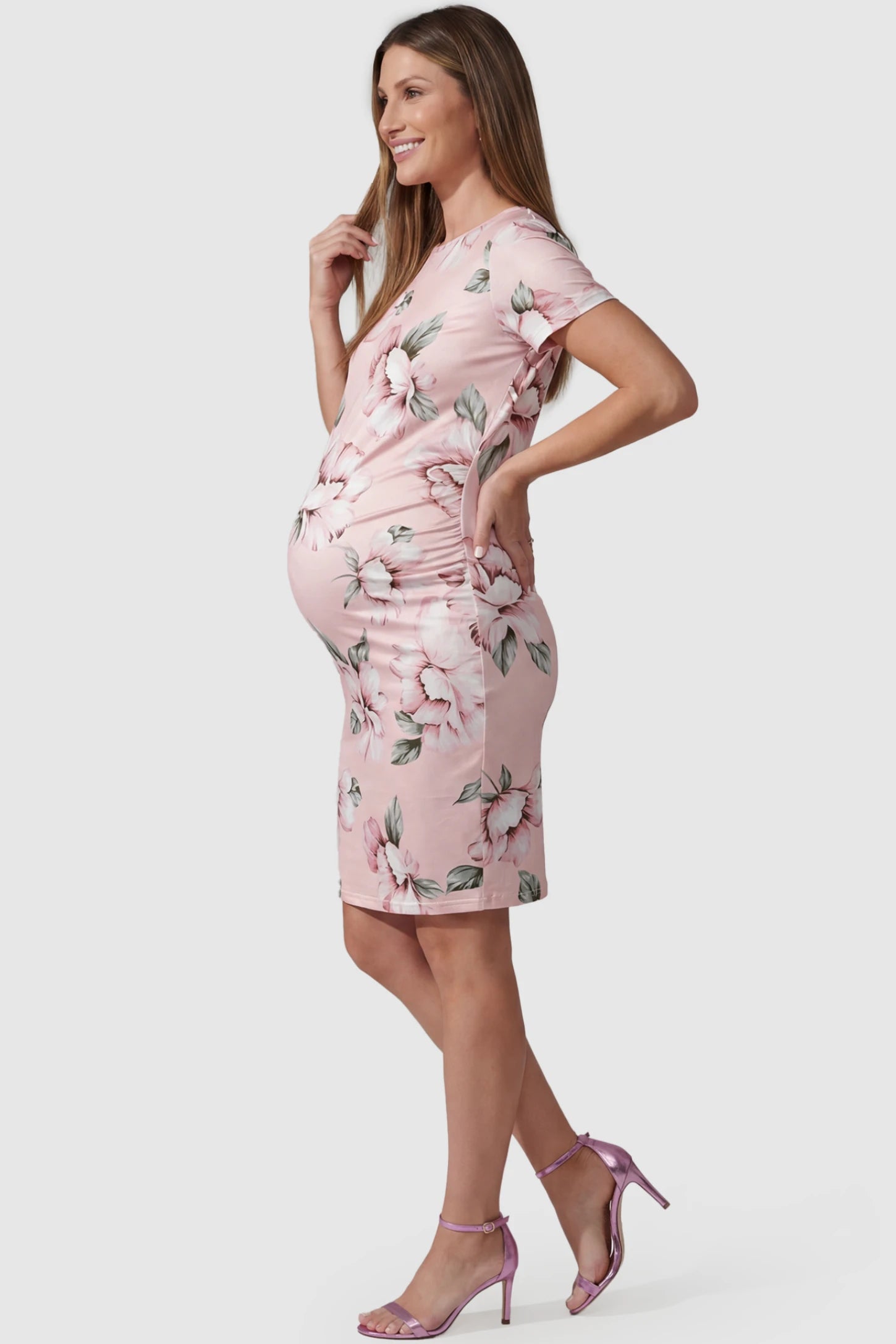 Floral Ruched Bodycon Maternity Short Dress Floral Ruched Bodycon Maternity Short Dress in pink floral featuring side ruching on pregnant model, side view.