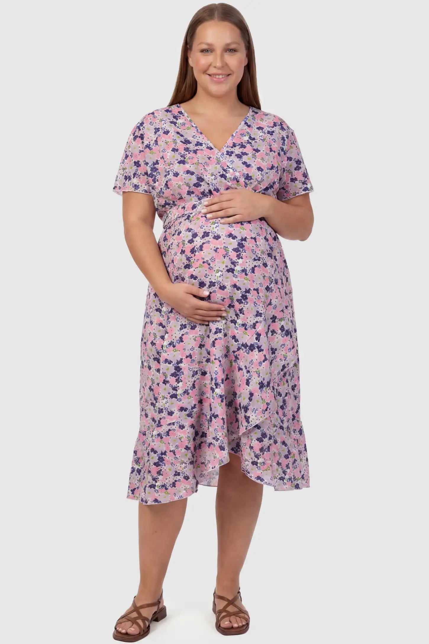 Floral V-Neck Ruffled Hem Midi Maternity Dress Floral V-neck ruffled hem midi maternity dress in apricot featuring V-neckline and tie waist in full body front view on a plus size pregnant model, front view.