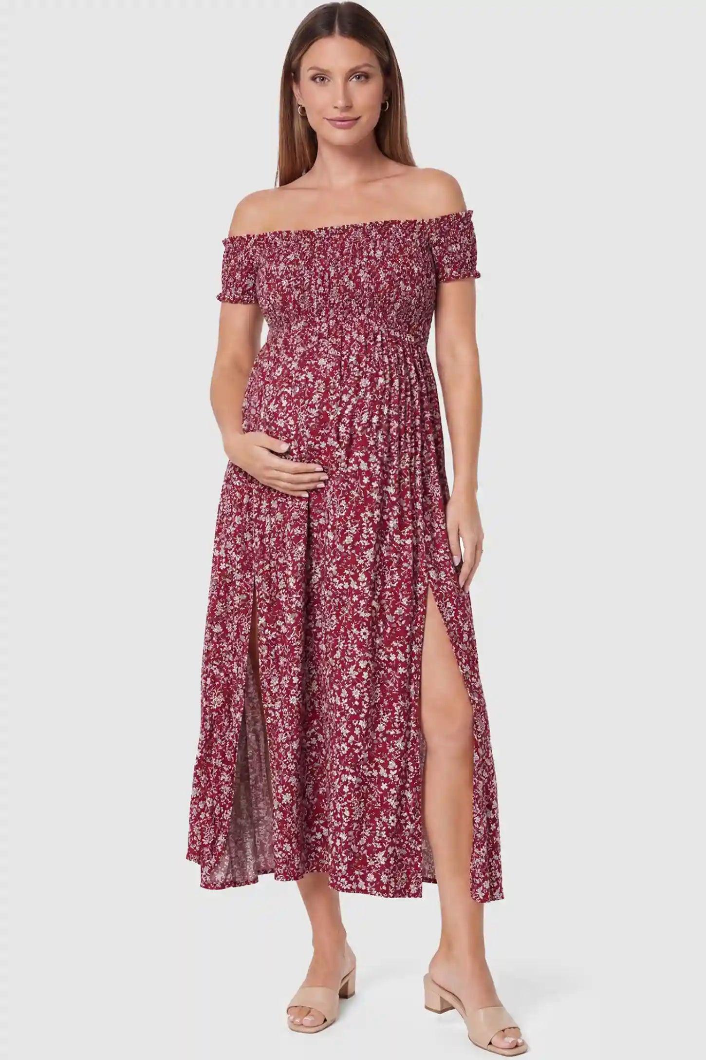 Floral off-shoulder smocked bodice maxi maternity dress in burgundy featuring smocked neckline in front view on a pregnant model