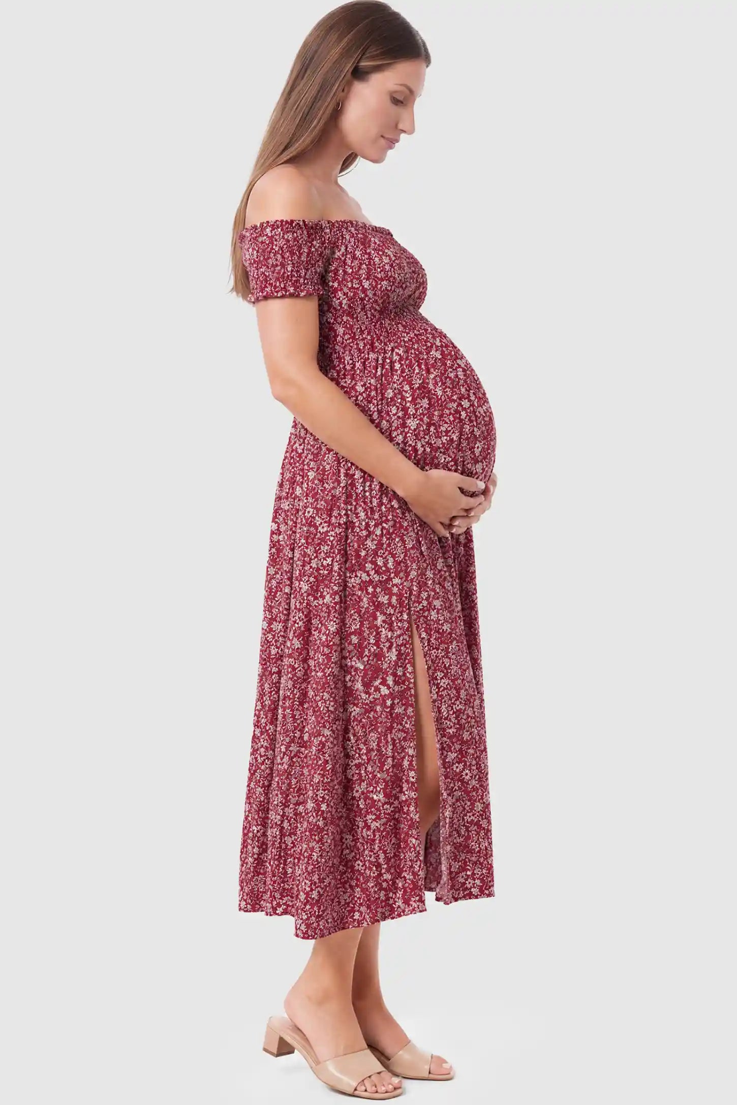Floral Off-Shoulder Smocked Bodice Maxi Maternity Dress Floral off-shoulder smocked bodice maxi maternity dress in burgundy featuring a flowy silhouette in side view on a pregnant model