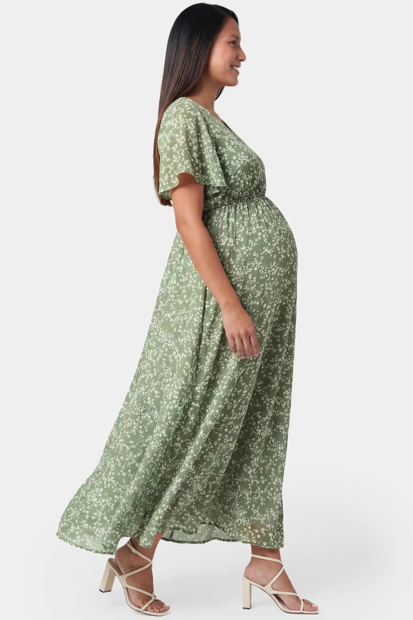 Floral V-neck short sleeve waist-cinching maxi maternity dress in light green featuring flutter sleeves in side view on a pregnant model