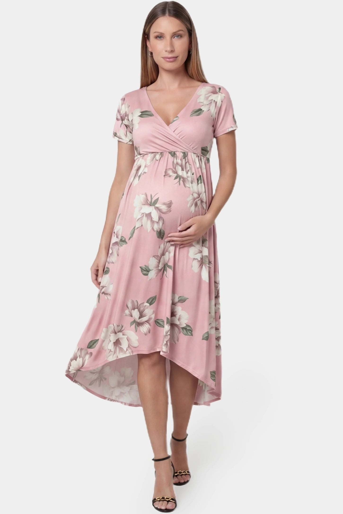 Floral V-neck wrap high-low maxi maternity dress in light pink floral featuring V-neck wrap-style front in front view on a pregnant model