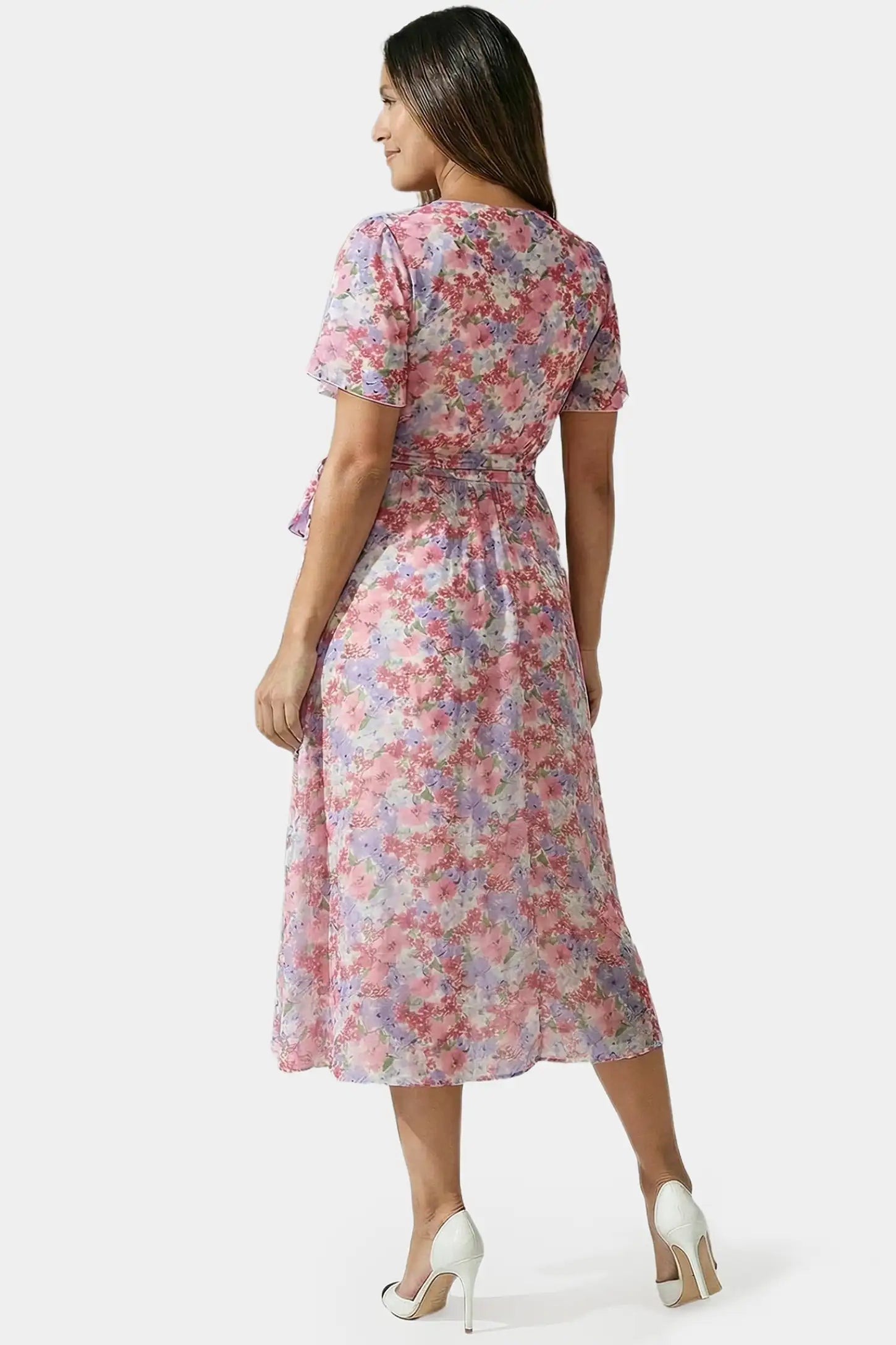 Floral V-Neck Ruffled Hem Midi Maternity Dress Floral V-neck ruffled hem midi maternity dress in pink featuring adjustable waist tie in back view on a pregnant model