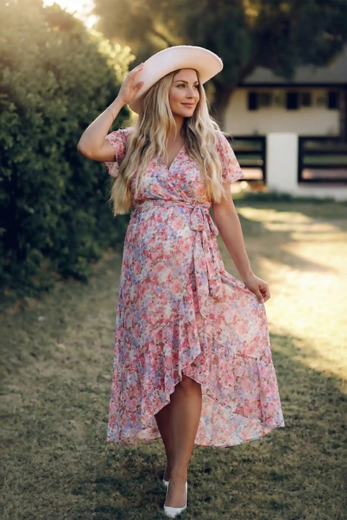 Floral V-neck ruffled hem midi maternity dress in pink with feminine floral print, on editorial lifestyle model