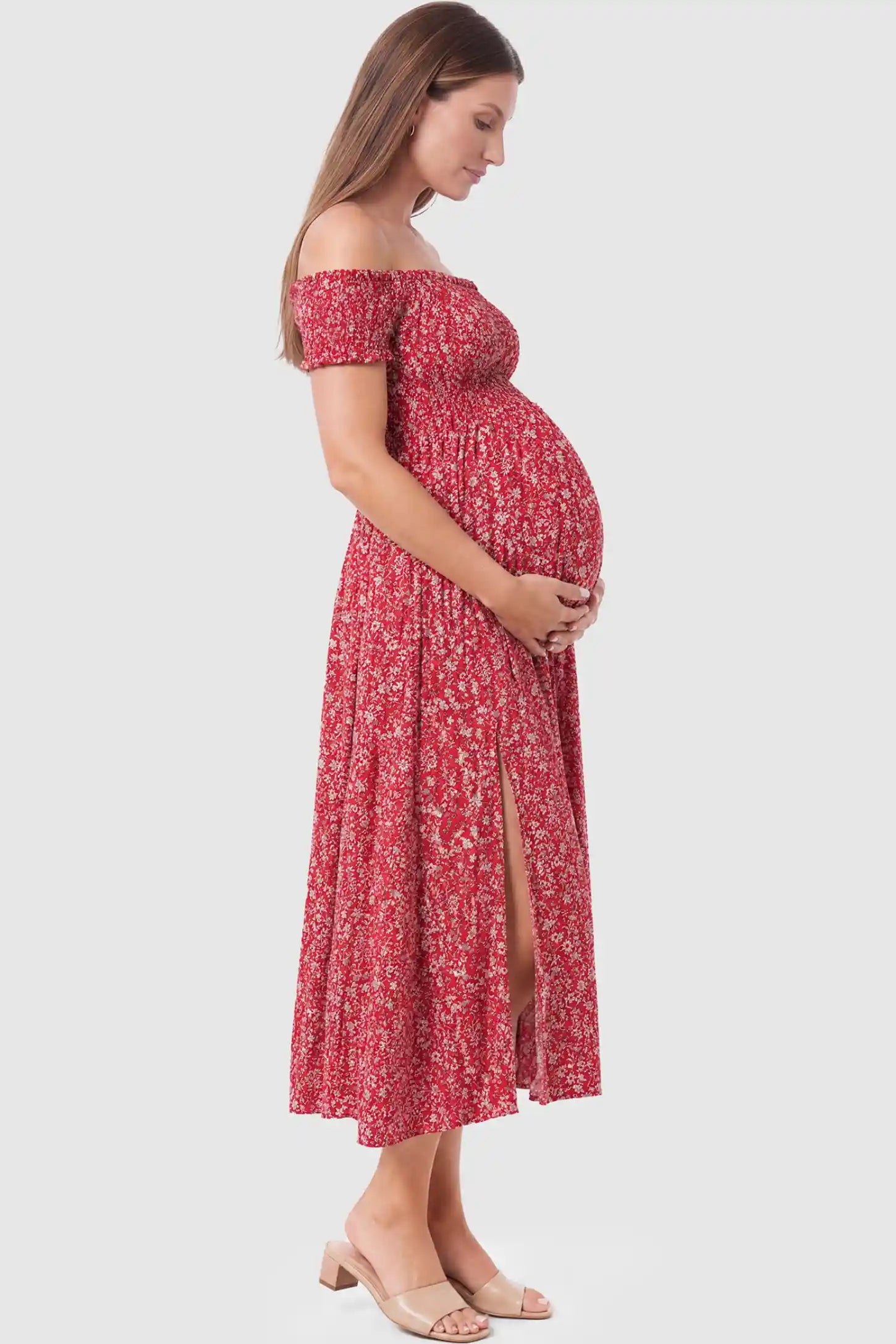 Floral Off-Shoulder Smocked Bodice Maxi Maternity Dress Floral off-shoulder smocked bodice maxi maternity dress in red featuring a flowy silhouette in side view on a pregnant model