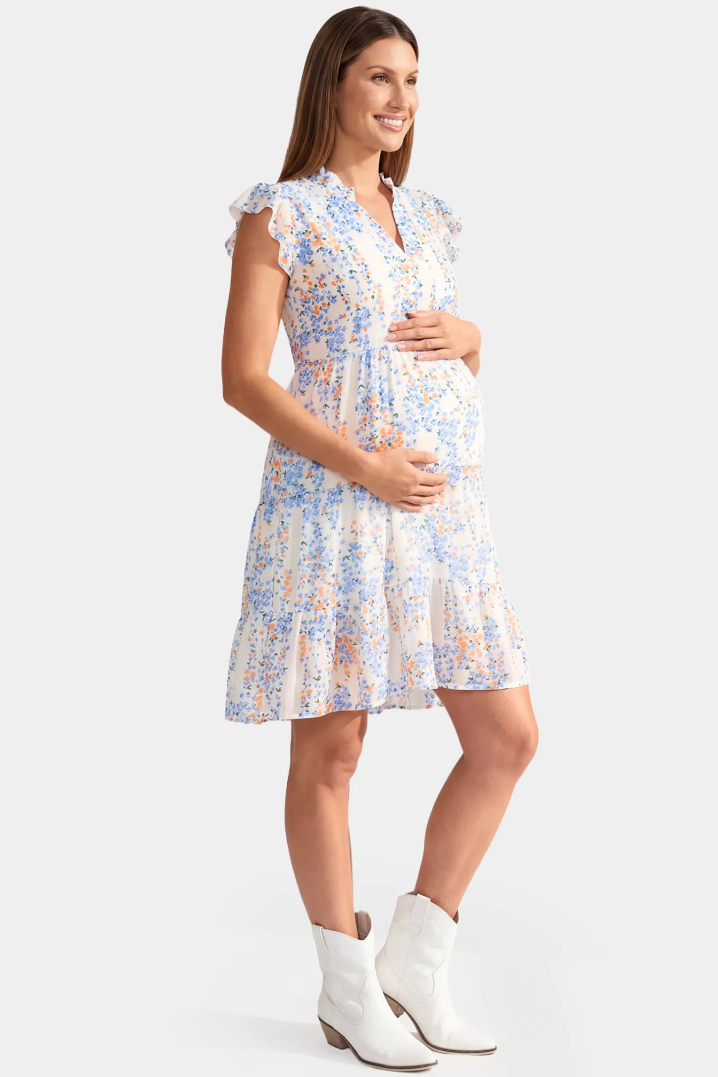 Floral V-Neck A-Line Short Maternity Dress in white featuring flutter sleeves in full body side view on a pregnant model