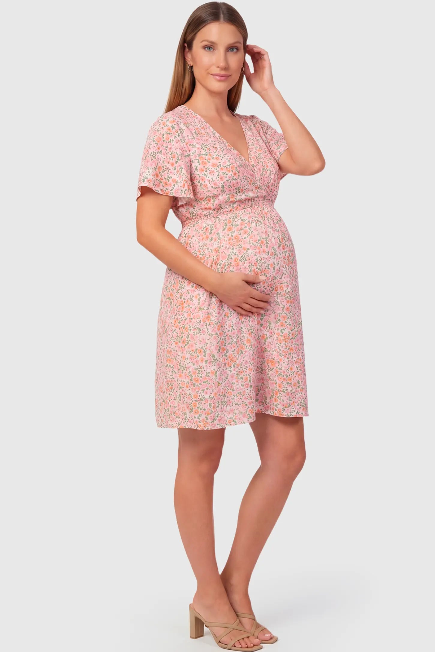 Short Sleeve A-Line Maternity Short Dress in pink floral featuring V-neck and empire waist on pregnant model.