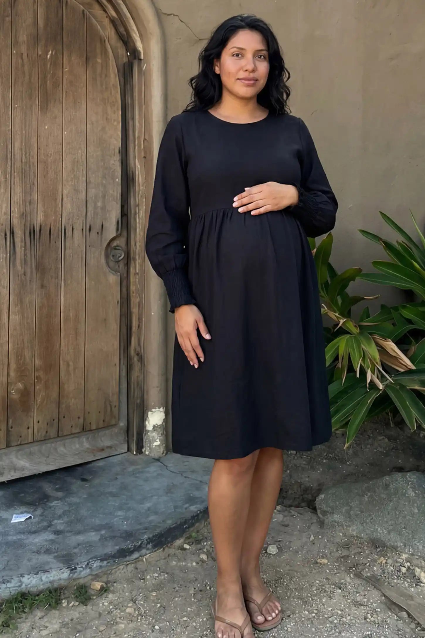 Balloon Sleeve Empire Waist Maternity Midi Dress in black featuring smocked elastic cuff sleeves and soft drape on a pregnant model.