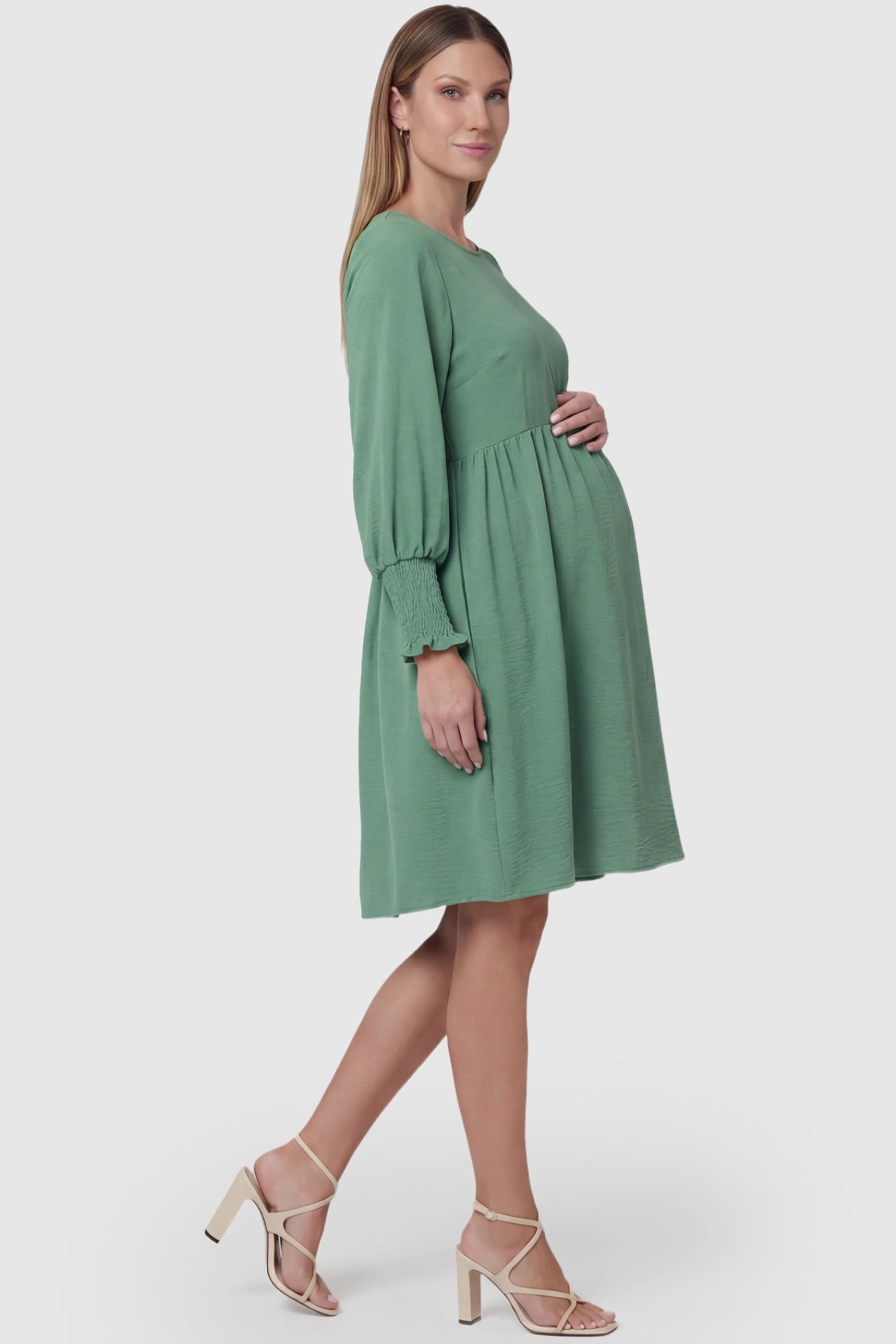 Balloon Sleeve Empire Waist Maternity Midi Dress Balloon Sleeve Empire Waist Maternity Midi Dress in light green featuring smocked elastic cuff sleeves and soft drape on a pregnant model, side view.