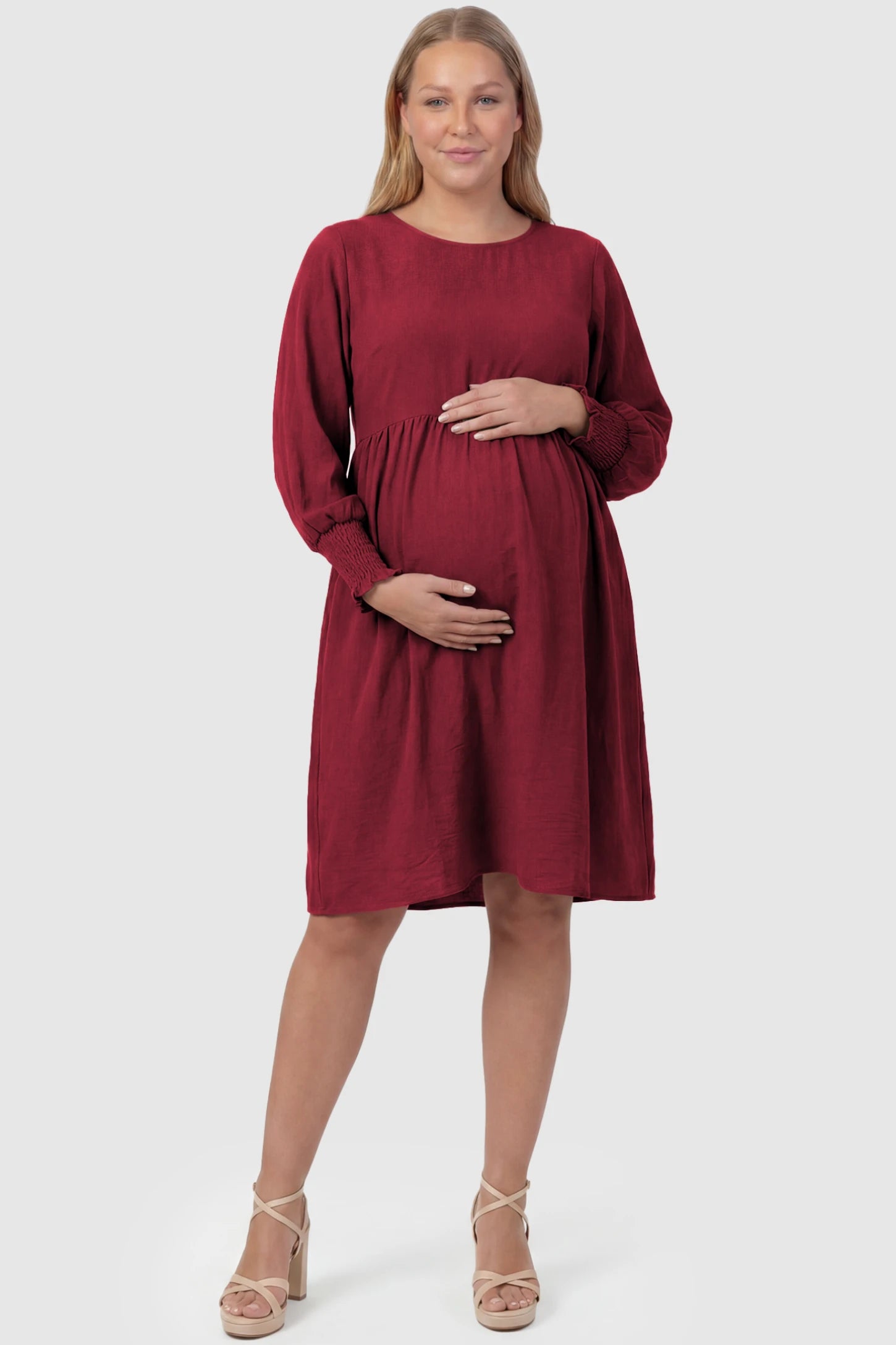 Balloon Sleeve Empire Waist Maternity Midi Dress Balloon Sleeve Empire Waist Maternity Midi Dress in red featuring smocked elastic cuff sleeves and soft drape on a plus size pregnant model, front view.