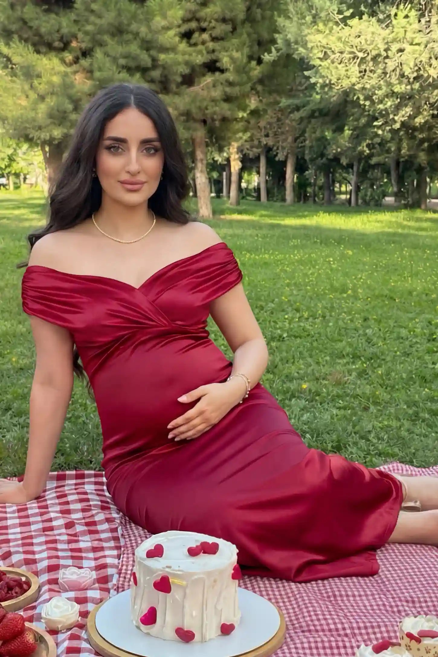 Off-Shoulder Fitted Waist Flowing Maxi Maternity Dress Off-shoulder fitted waist flowing maxi maternity dress in red featuring off-shoulder neckline in front view on a pregnant model