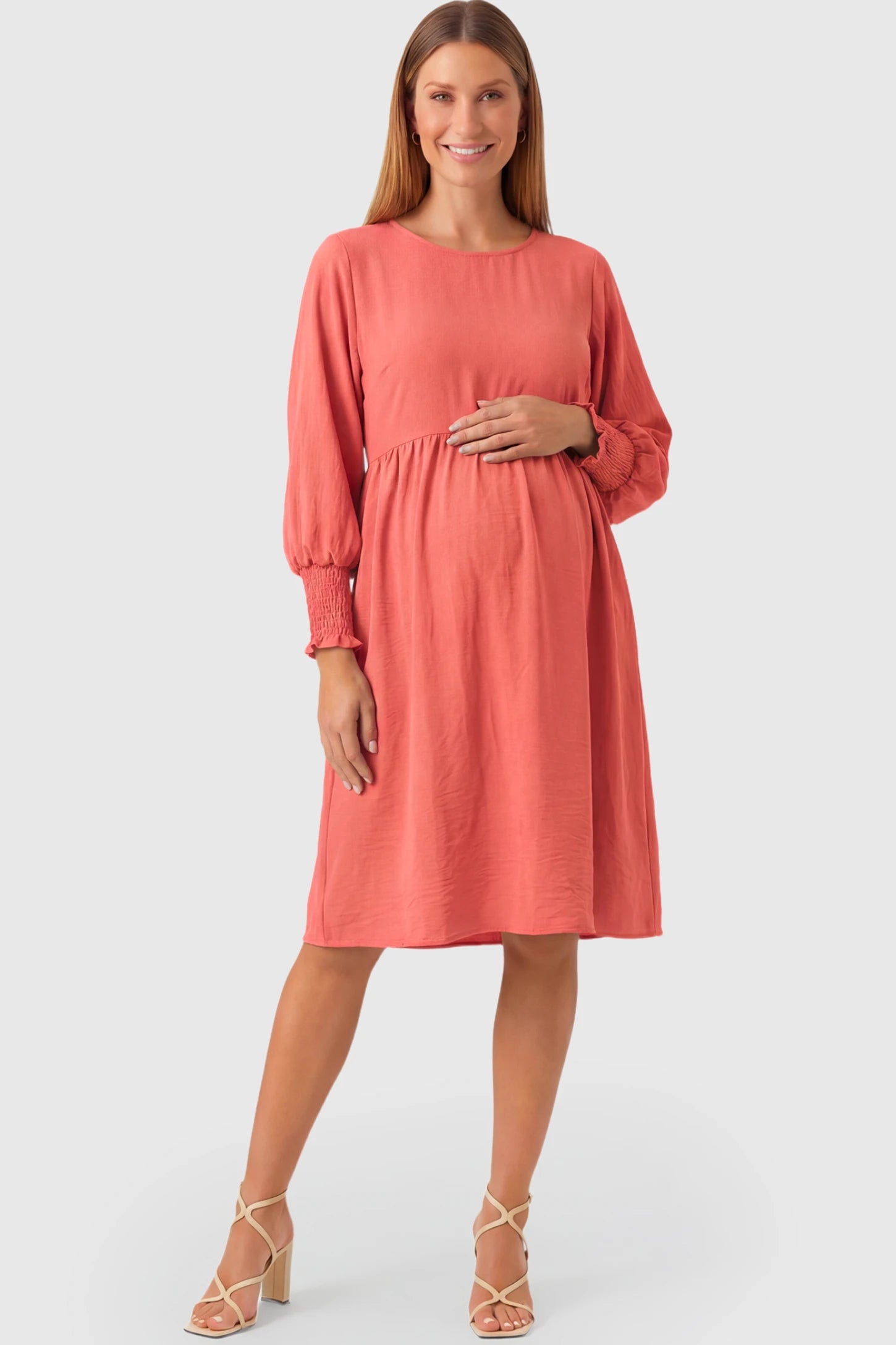 Balloon Sleeve Empire Waist Maternity Midi Dress in watermelon red featuring smocked elastic cuff sleeves and soft drape on a pregnant model.