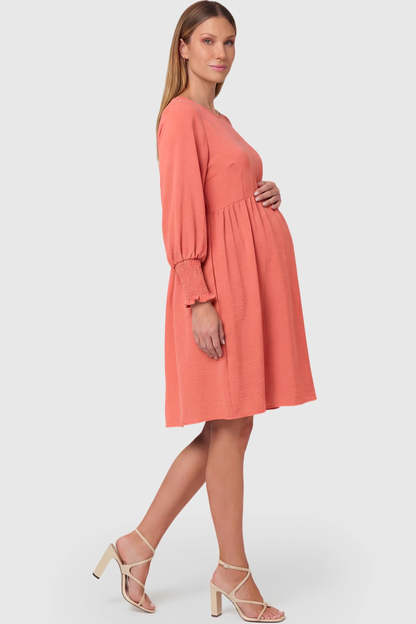 Balloon Sleeve Empire Waist Maternity Midi Dress in watermelon red featuring smocked elastic cuff sleeves and soft drape on a pregnant model.