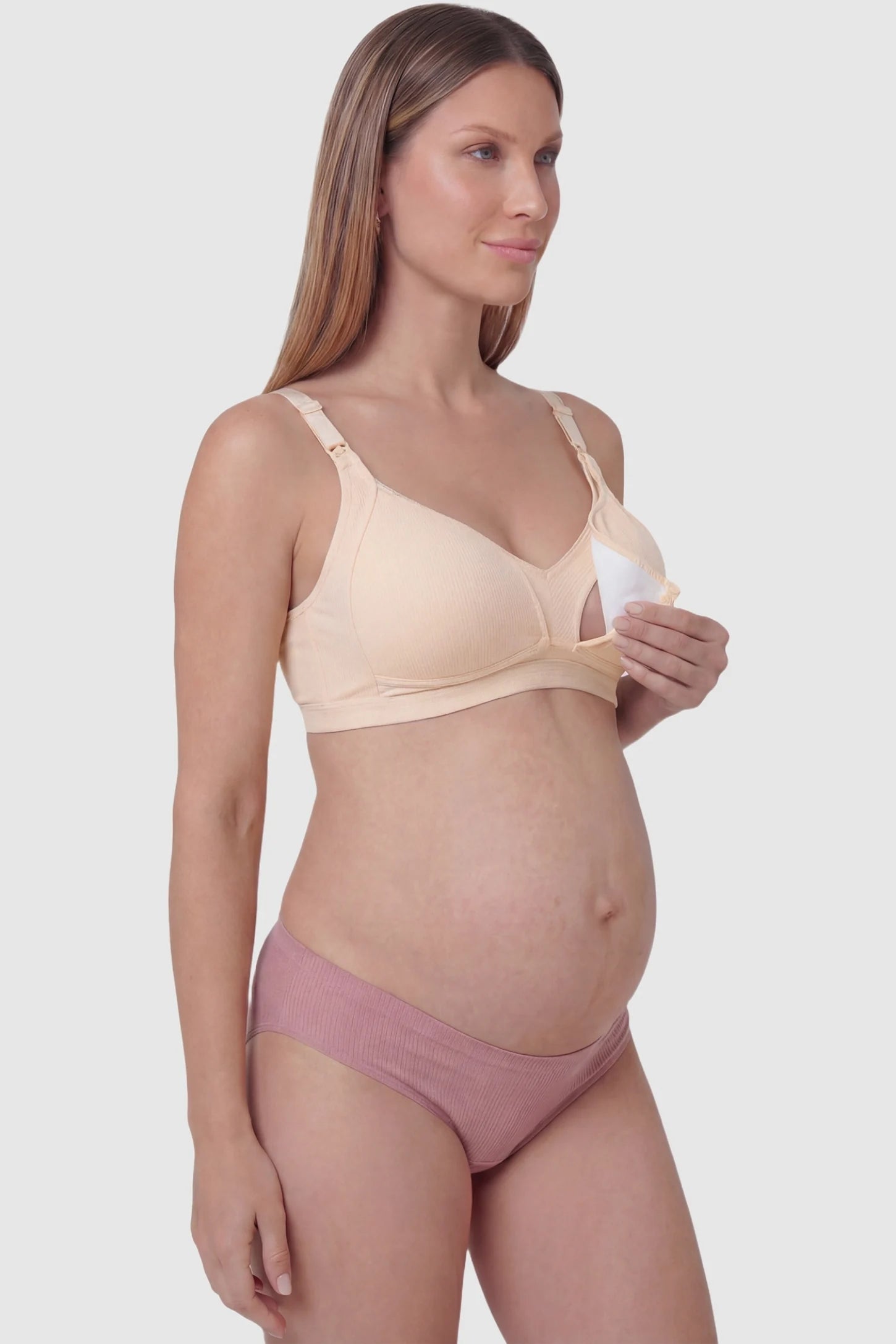 Front-Open Snap Wire-Free Maternity Nursing Bra Front-Open Buckle Wire-Free Maternity Nursing Bra in Skin featuring breathable cotton fabric on a side view of a pregnant model.