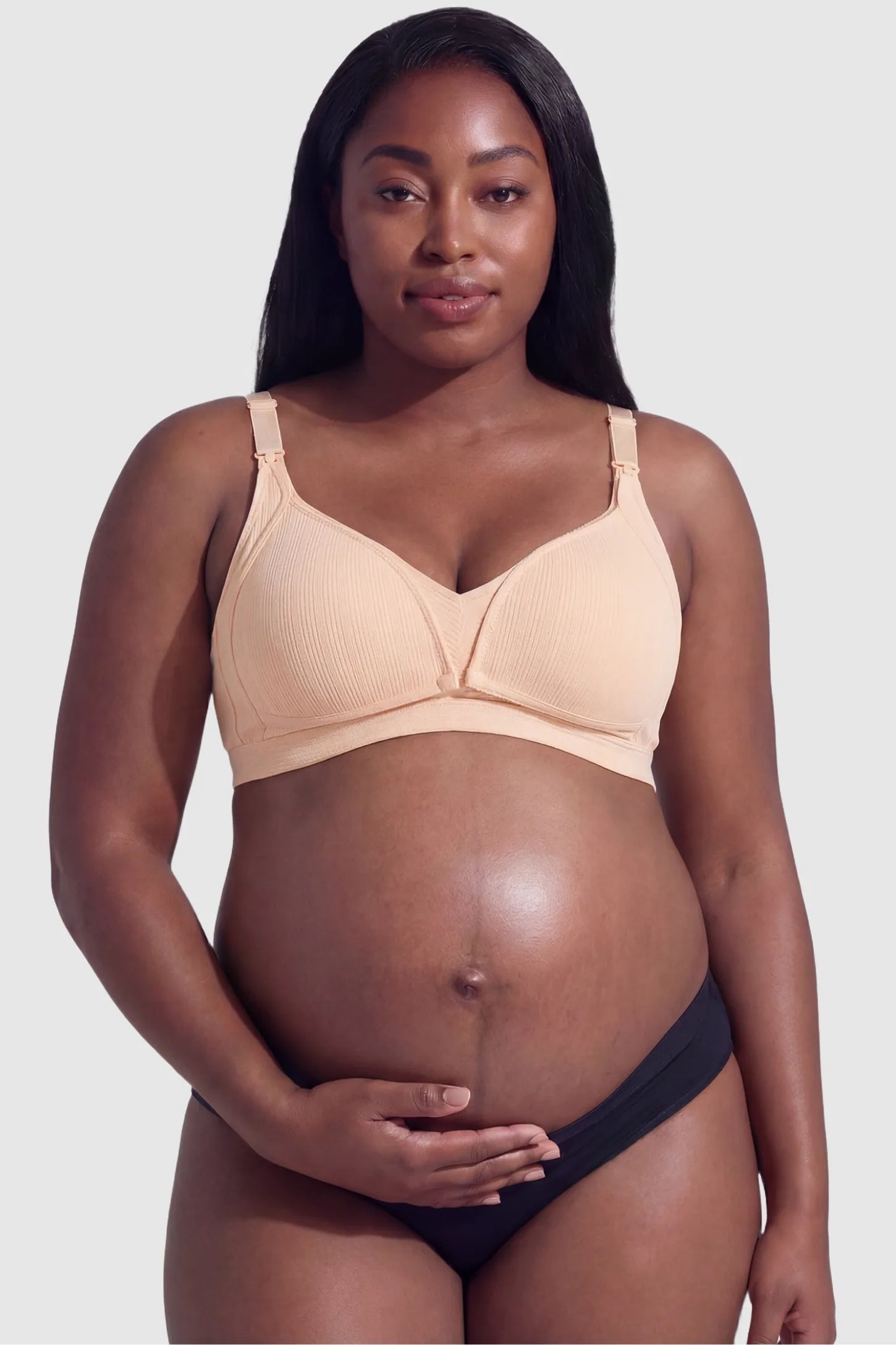 Front-Open Snap Wire-Free Maternity Nursing Bra Front-Open Buckle Wire-Free Maternity Nursing Bra in Skin featuring supportive wire-free cups on a front view of a plus size pregnant model.