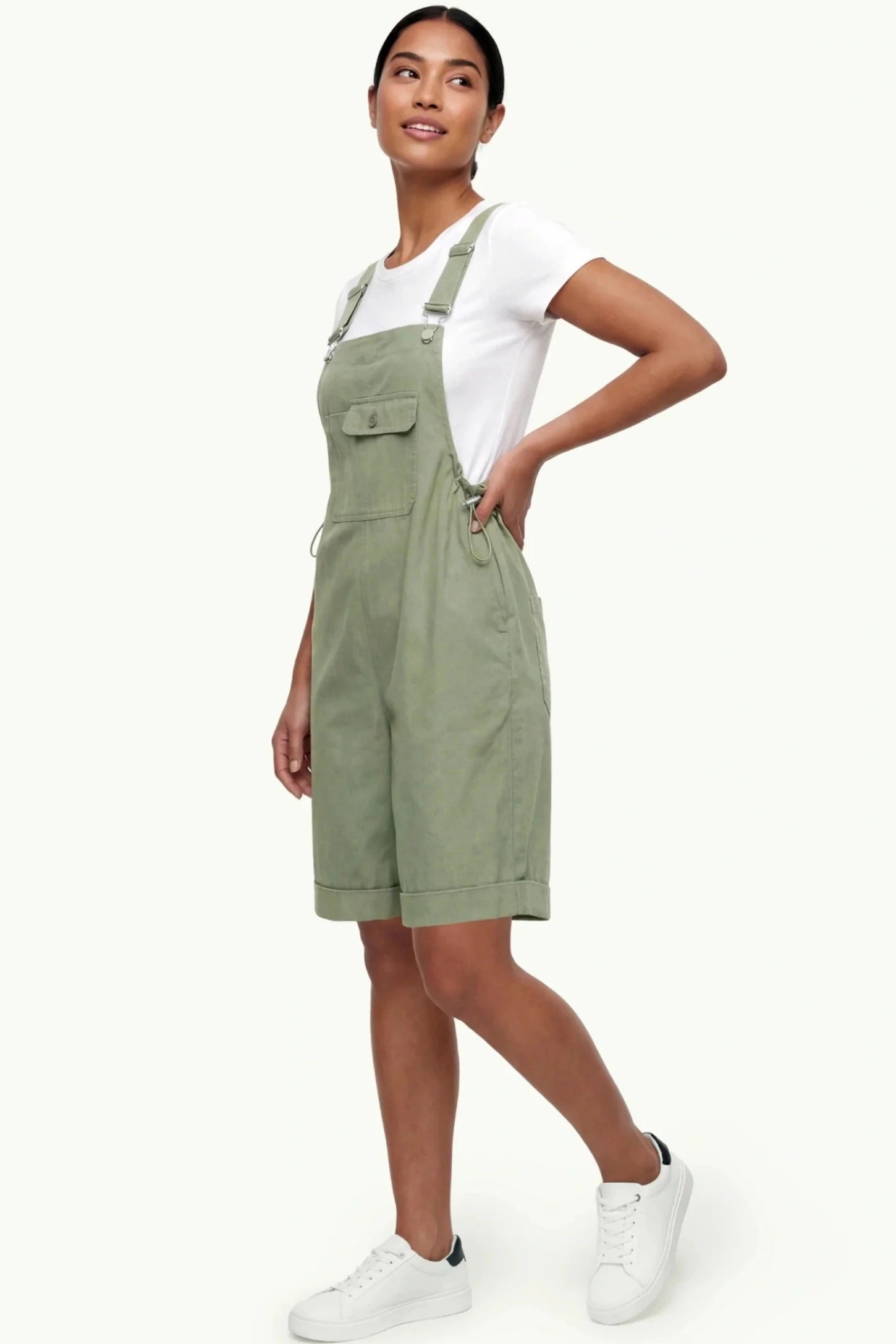 Oversized Front Pocket Maternity Overalls Shorts Oversized Front Pocket Maternity Overalls Shorts in Green featuring a front bib pocket on a non-pregnant model.