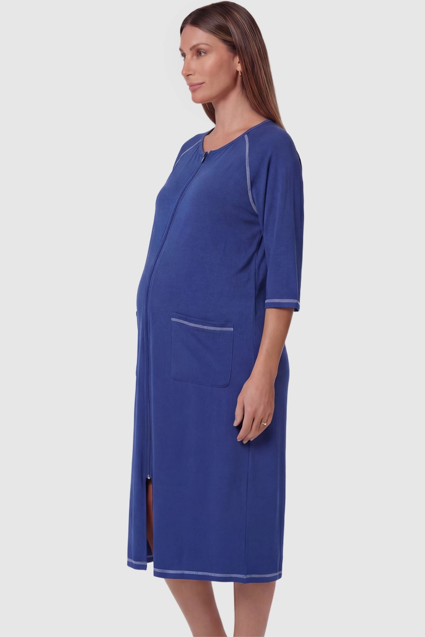 Front Zipper Three-Quarter Sleeve Midi Maternity & Nursing Dress Front zipper three-quarter sleeve midi maternity and nursing dress in blue featuring functional pockets and three-quarter sleeves in side view on a pregnant model