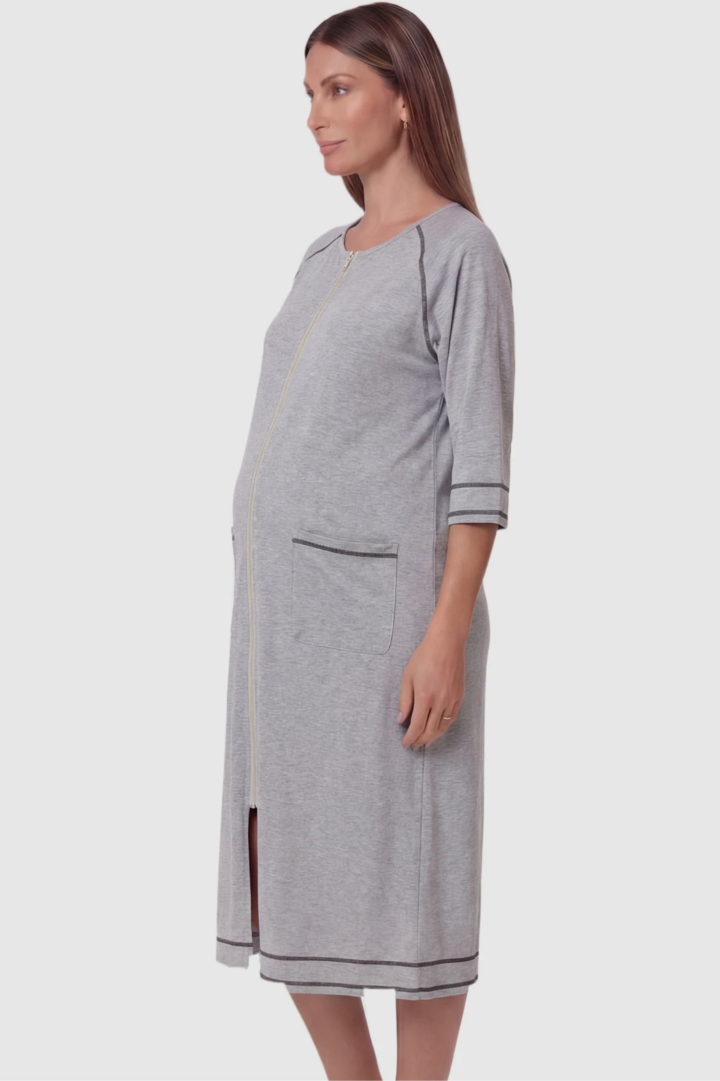 Front Zipper Three-Quarter Sleeve Midi Maternity & Nursing Dress Front zipper three-quarter sleeve midi maternity and nursing dress in light gray featuring functional pockets and three-quarter sleeves in side view on a pregnant model