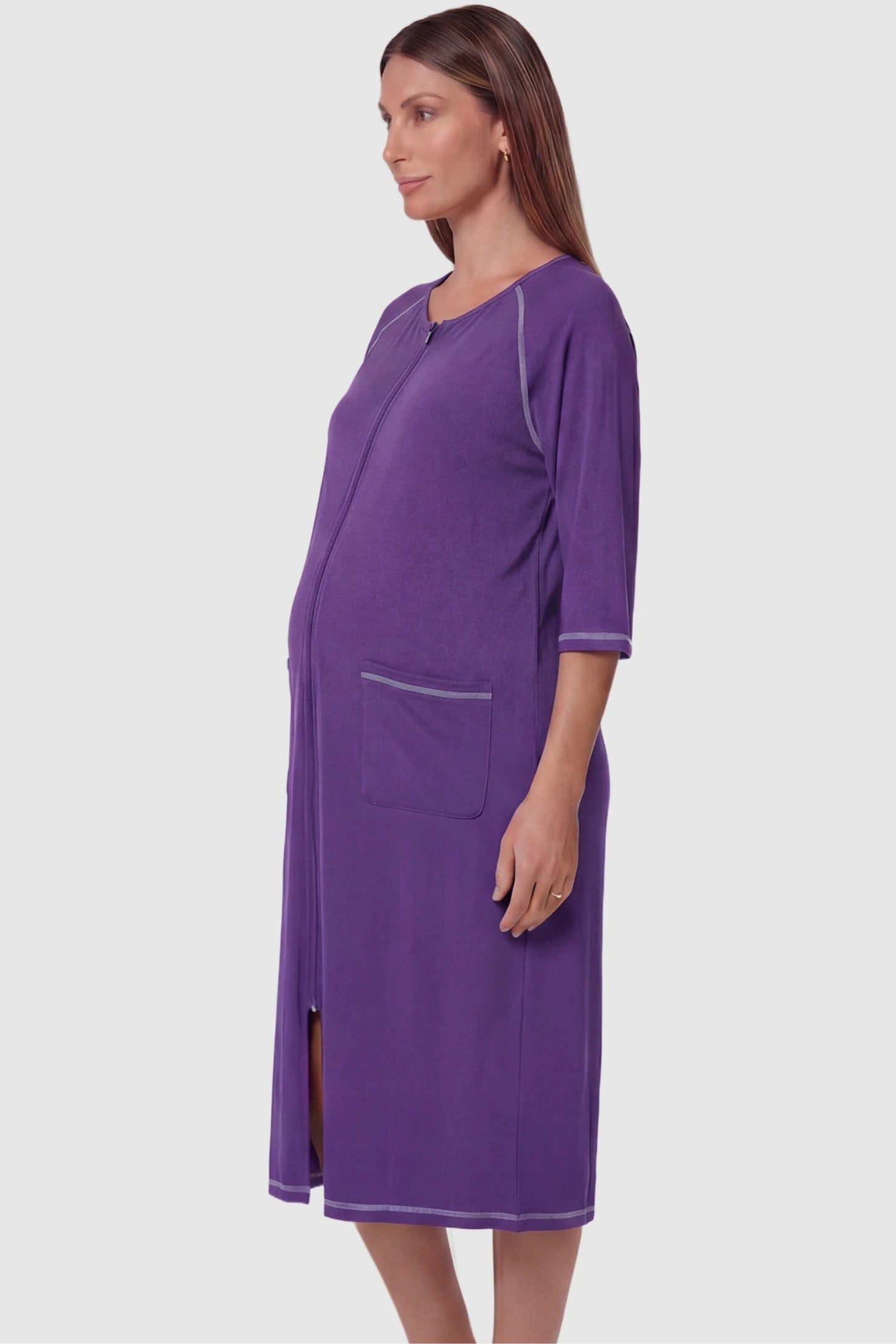 Front Zipper Three-Quarter Sleeve Midi Maternity & Nursing Dress Front zipper three-quarter sleeve midi maternity and nursing dress in purple featuring functional pockets and three-quarter sleeves in side view on a pregnant model
