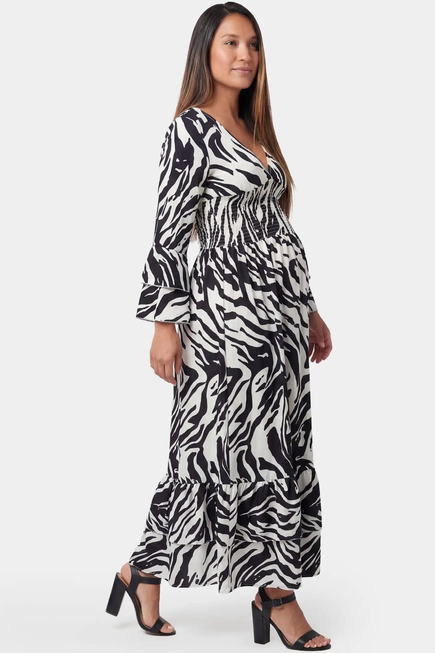 Geometric stripe print V-neck long sleeve tiered maxi maternity dress in black featuring tiered skirt design in side view on a pregnant model