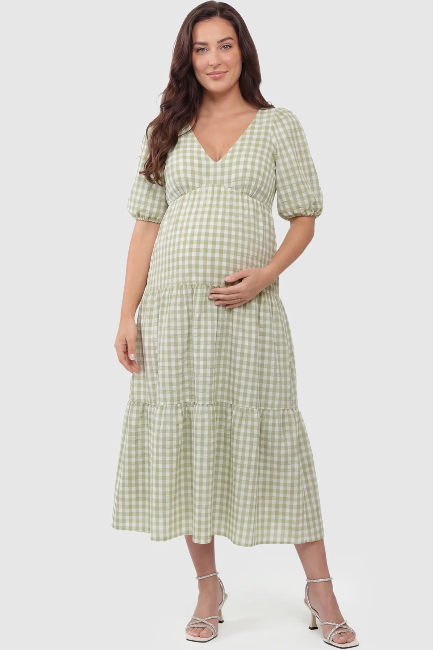 Gingham V-Neck Tiered Midi Maternity Dress Gingham V-Neck Tiered Midi Maternity Dress in green featuring a flowing tiered silhouette in front view on a plus-size model