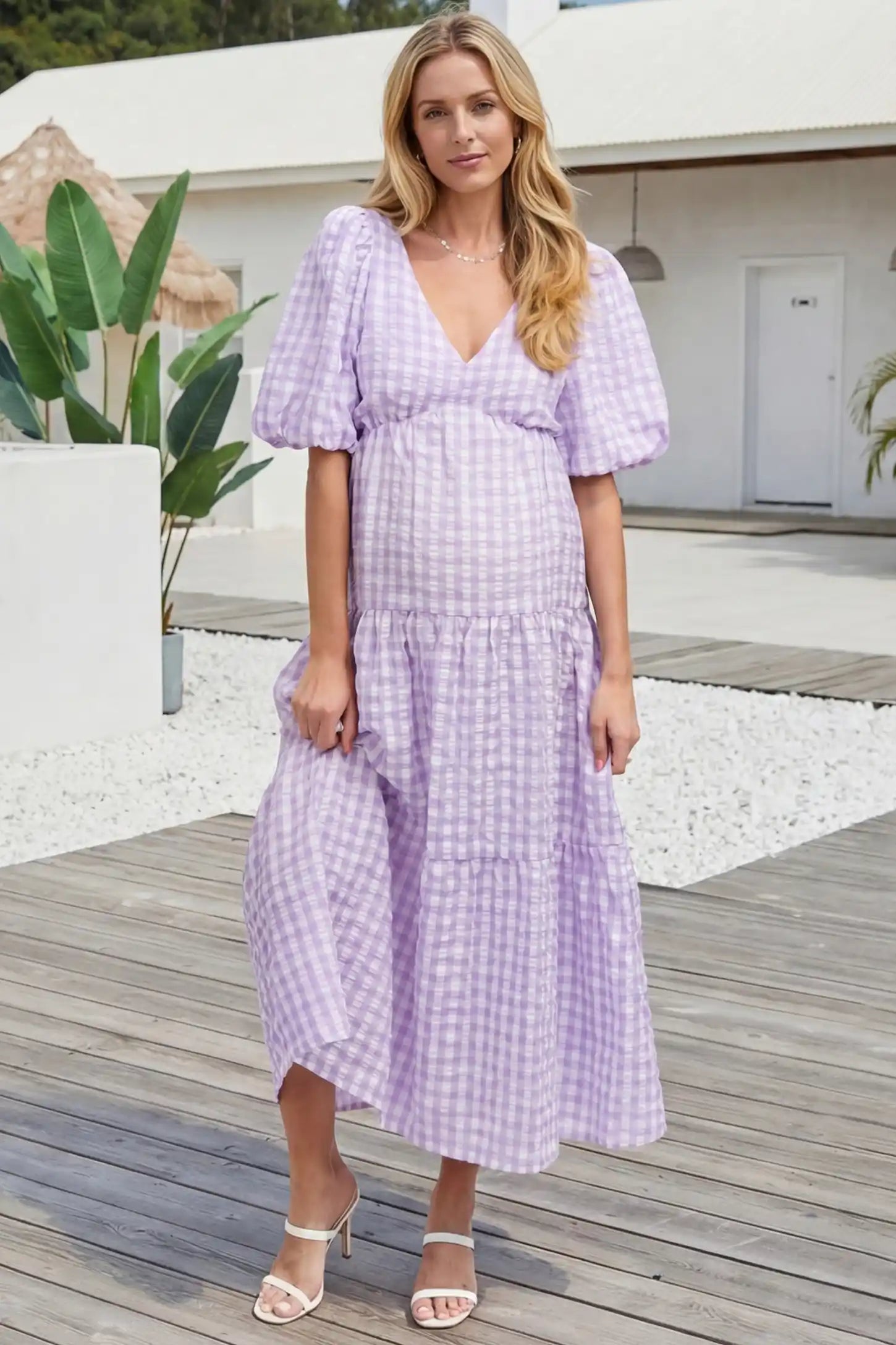 Gingham V-neck tiered maxi maternity dress in lavender with vintage-inspired gingham pattern, on an editorial lifestyle model