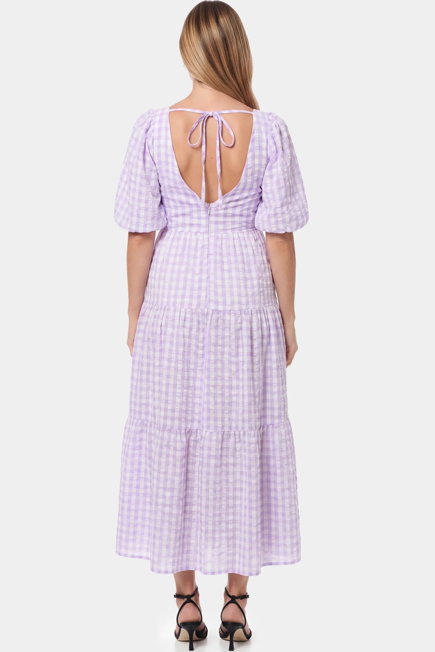 Gingham V-Neck Tiered Maxi Maternity Dress Gingham V-Neck Tiered Maxi Maternity Dress in lavender featuring an adjustable tie in back view on a pregnant model