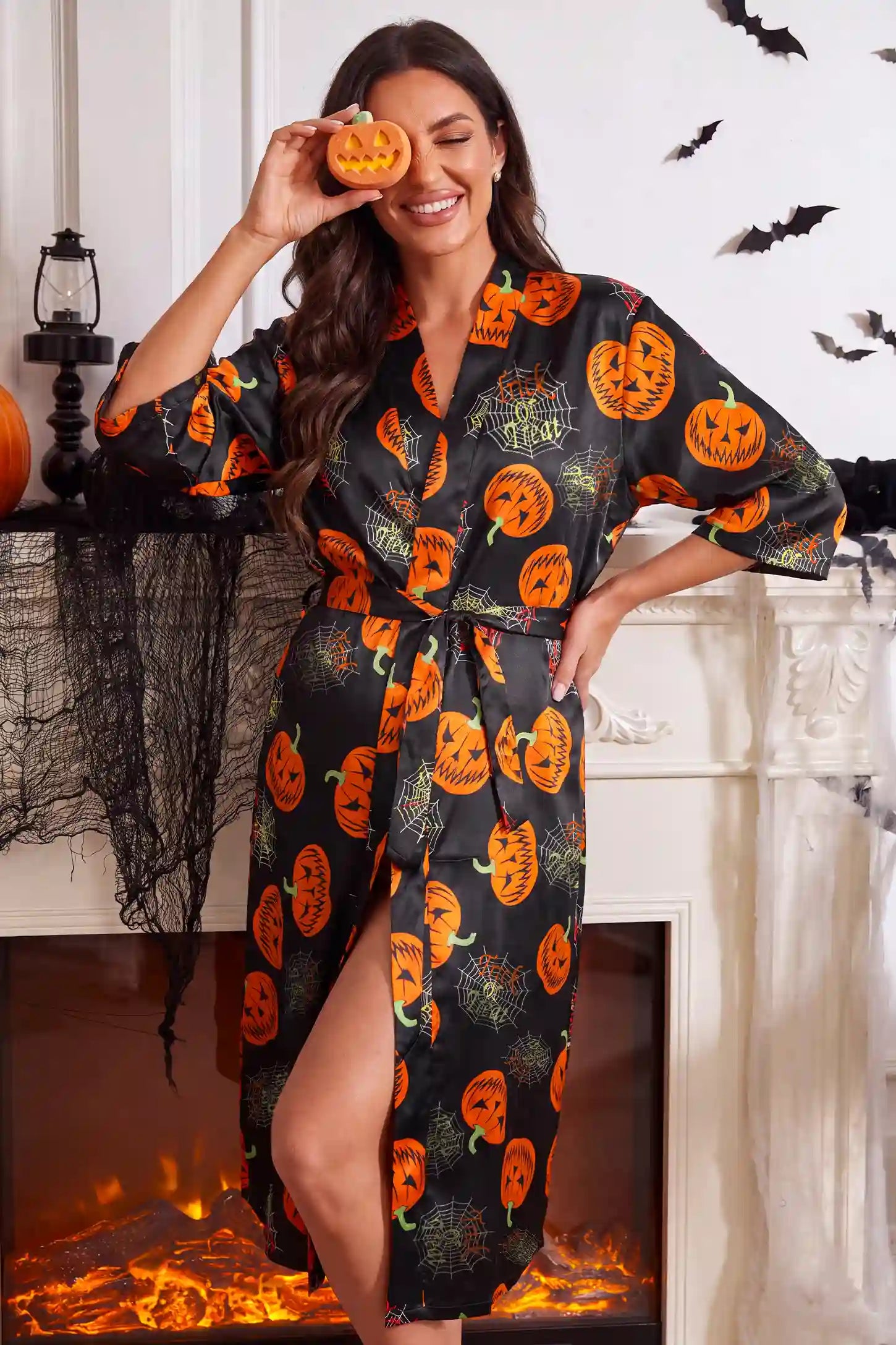 Halloween Pumpkin Print Satin Maternity Lounge Robe in Midnight Pumpkin featuring whimsical pumpkin pattern print, waist tie closure, relaxed fit, and soft stretch loungewear style on a pregnant model, full-body front view.