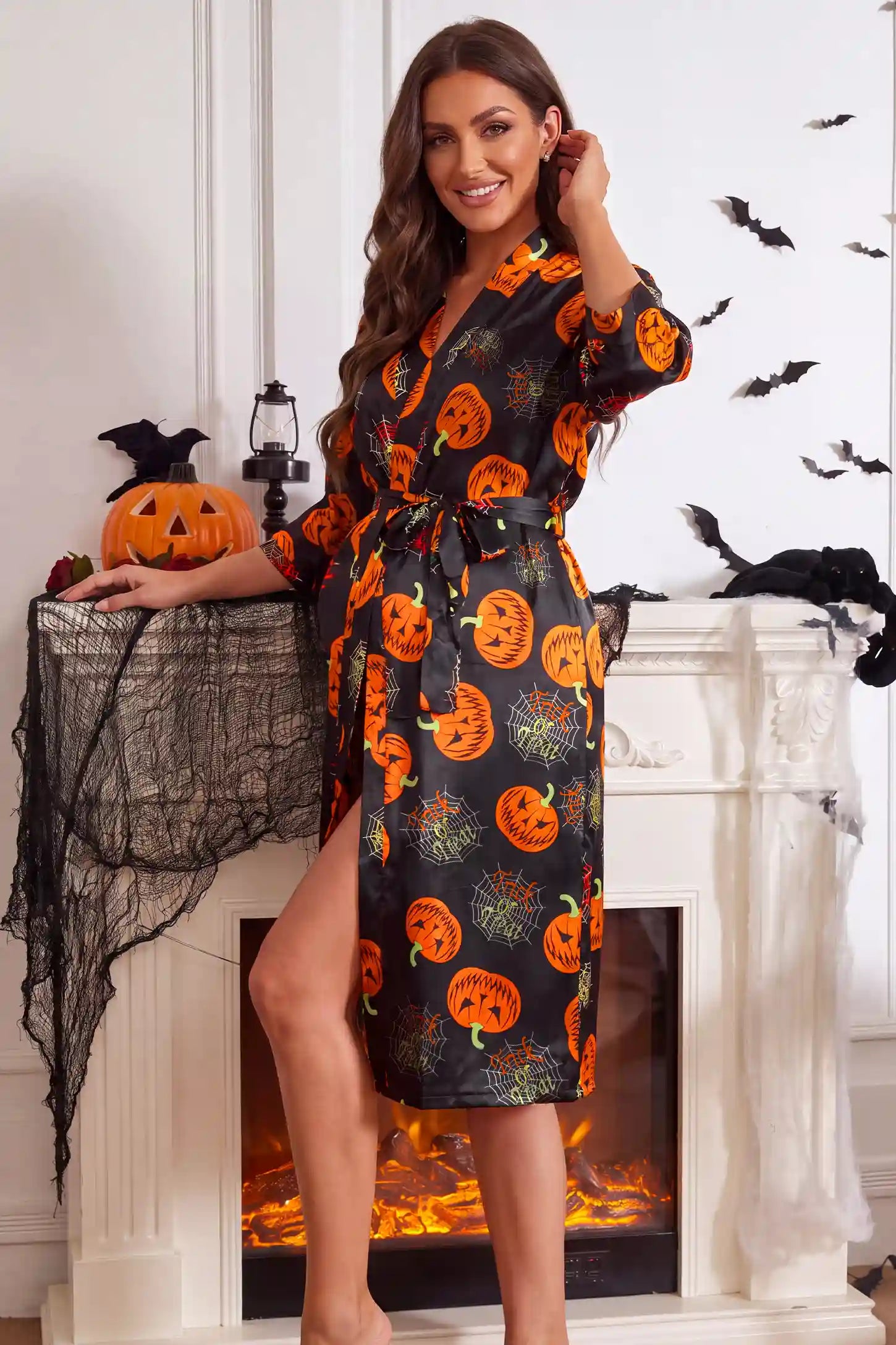 Halloween Pumpkin Print Satin Maternity Lounge Robe in Midnight Pumpkin featuring accommodating bump stretch design, side opening wrap style, and relaxed fit silhouette on a pregnant model, side view.