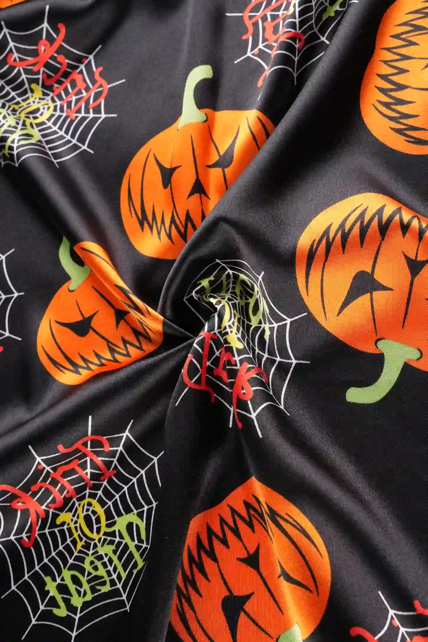 Halloween Pumpkin Print Satin Maternity Lounge Robe Halloween Pumpkin Print Satin Maternity Lounge Robe in Midnight Pumpkin featuring vibrant pumpkin and spiderweb print, smooth satin texture, and soft stretch material, close-up fabric view.
