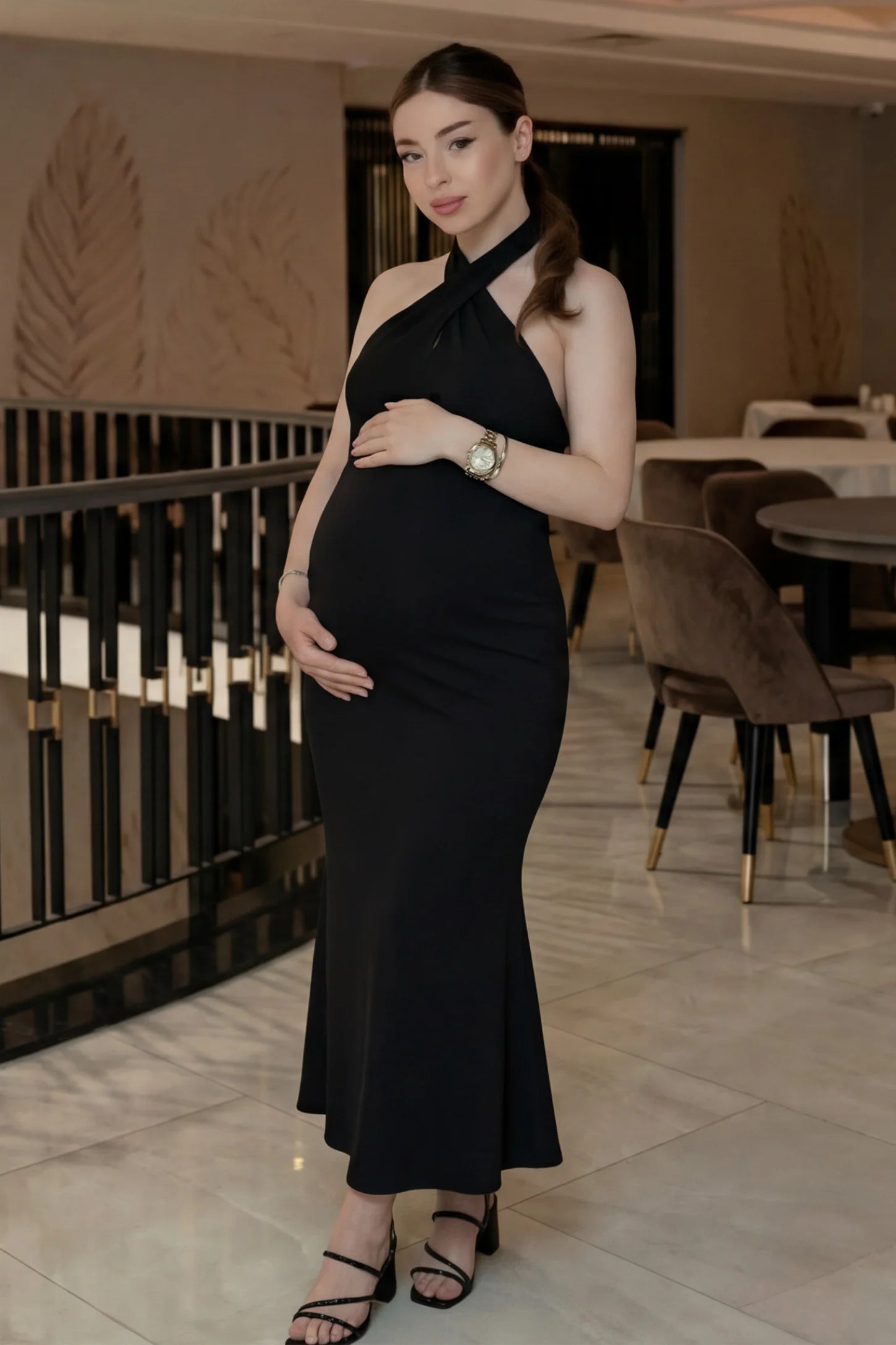 Halter Neck Sleeveless Maternity Maxi Dress Halter Neck Sleeveless Maternity Maxi Dress in black featuring a backless halter neckline and fitted maxi silhouette on a pregnant model.